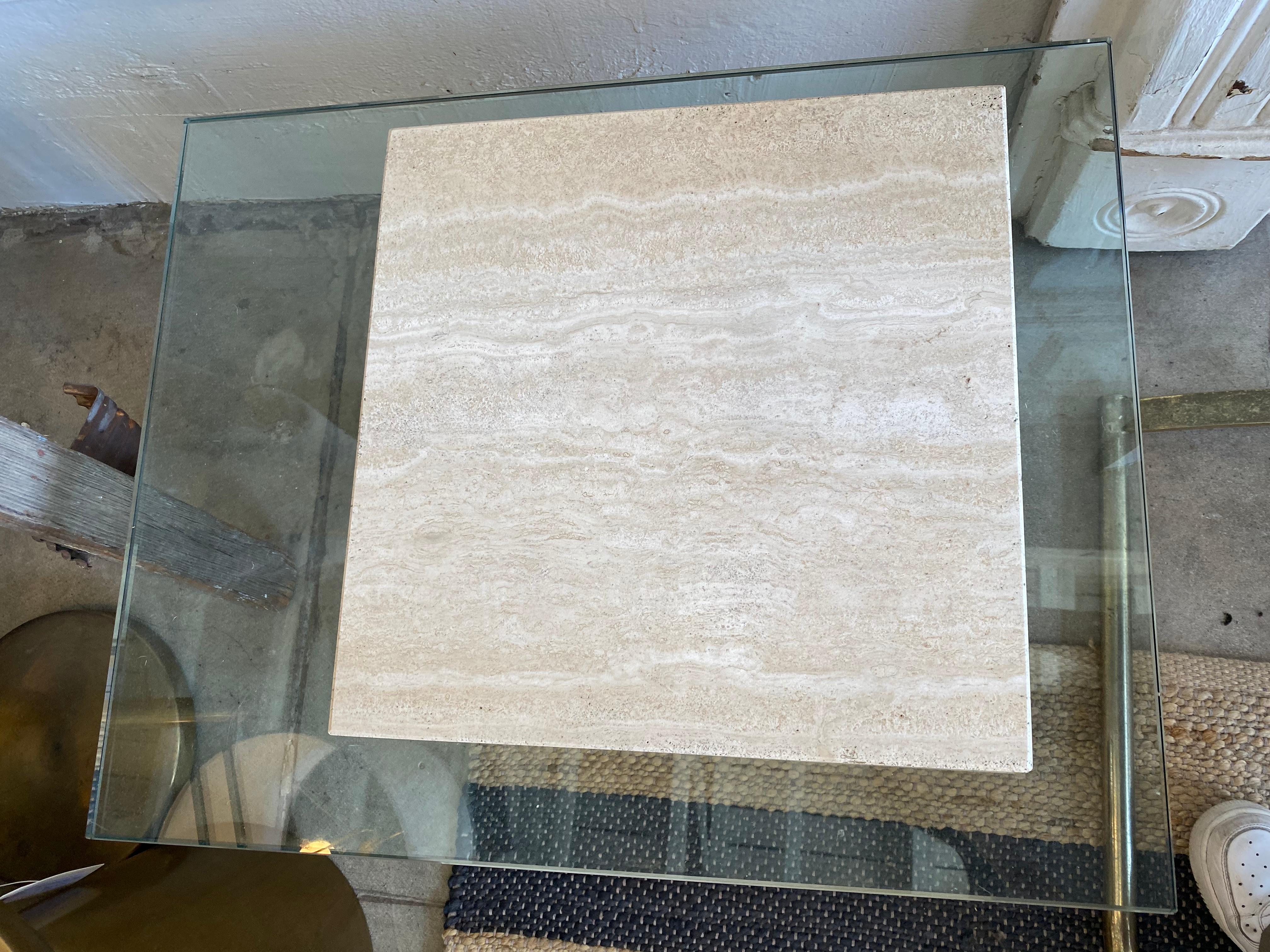 Modern travertine table with offset glass top. Constructed from one solid piece of Travertine, the glass top sits between the base and a cut-out top. The glass can be removed for ease of transport, travertine top is fixed to the glass. A beautiful