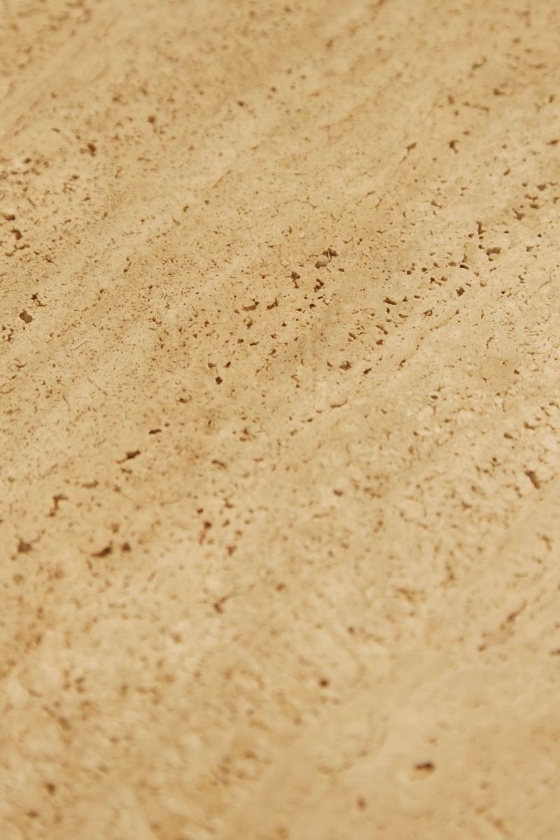 Ein skulpturaler Couchtisch aus Travertin mit minimalistischem Design. Die abgerundete quadratische Platte und der zylindrische Sockel heben die natürliche Textur und die warmen Farbtöne des Steins hervor.