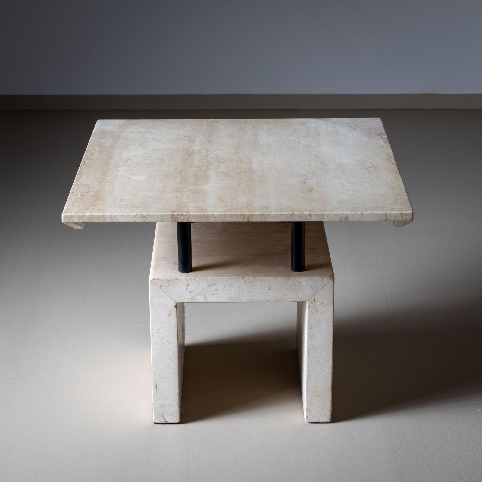 Side table made of travertine with a square table top with trapezoidal side sections over four black metal rods and an equally square base. 