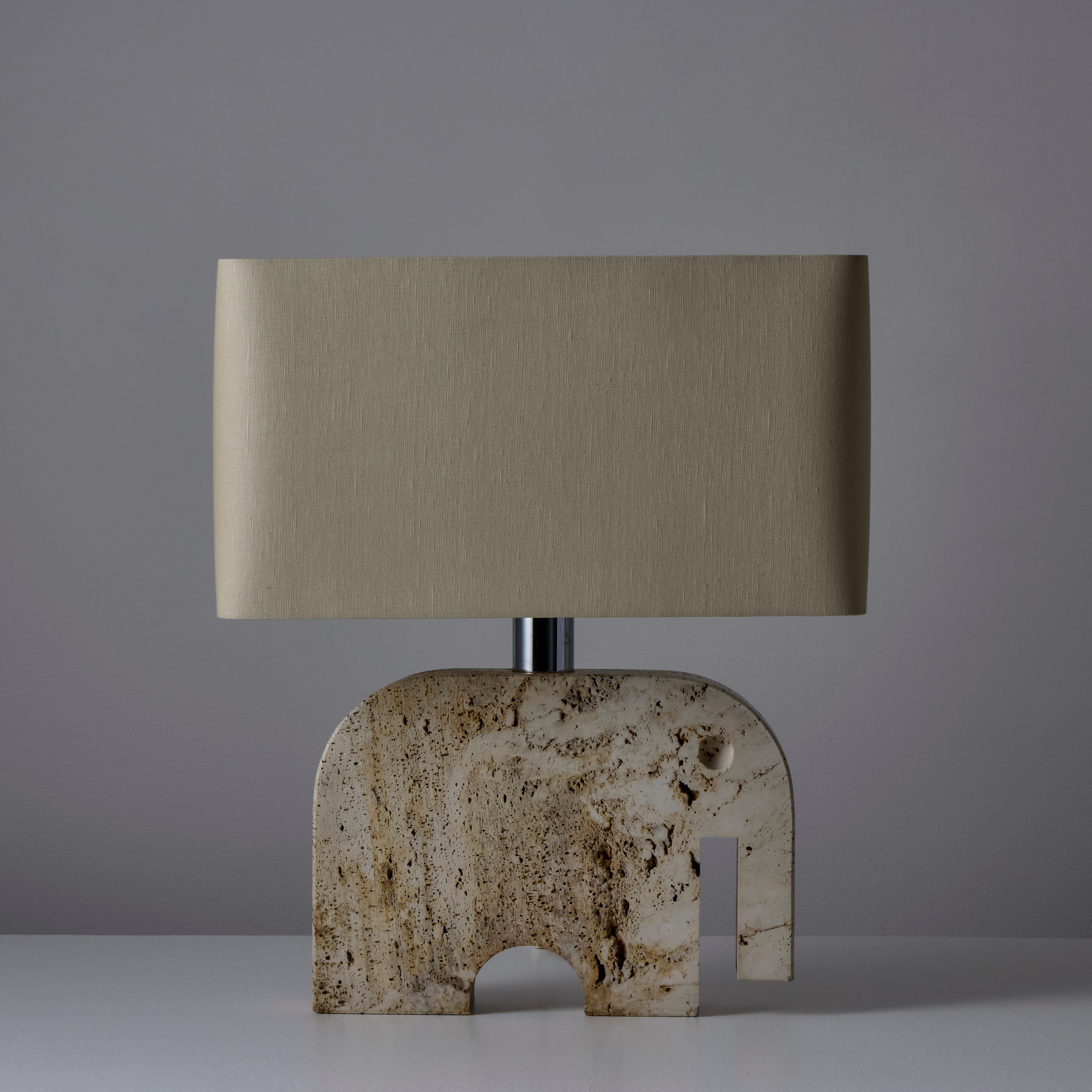 Travertine elephant table lamp manufactured by Fratelli Manelli in Italy, circa 1970s. Chromed brass stem. Original cord. Custom linen shade included. Takes one E26 60w maximum bulb or LED equivalent. Retains original manufacturer's label. Height