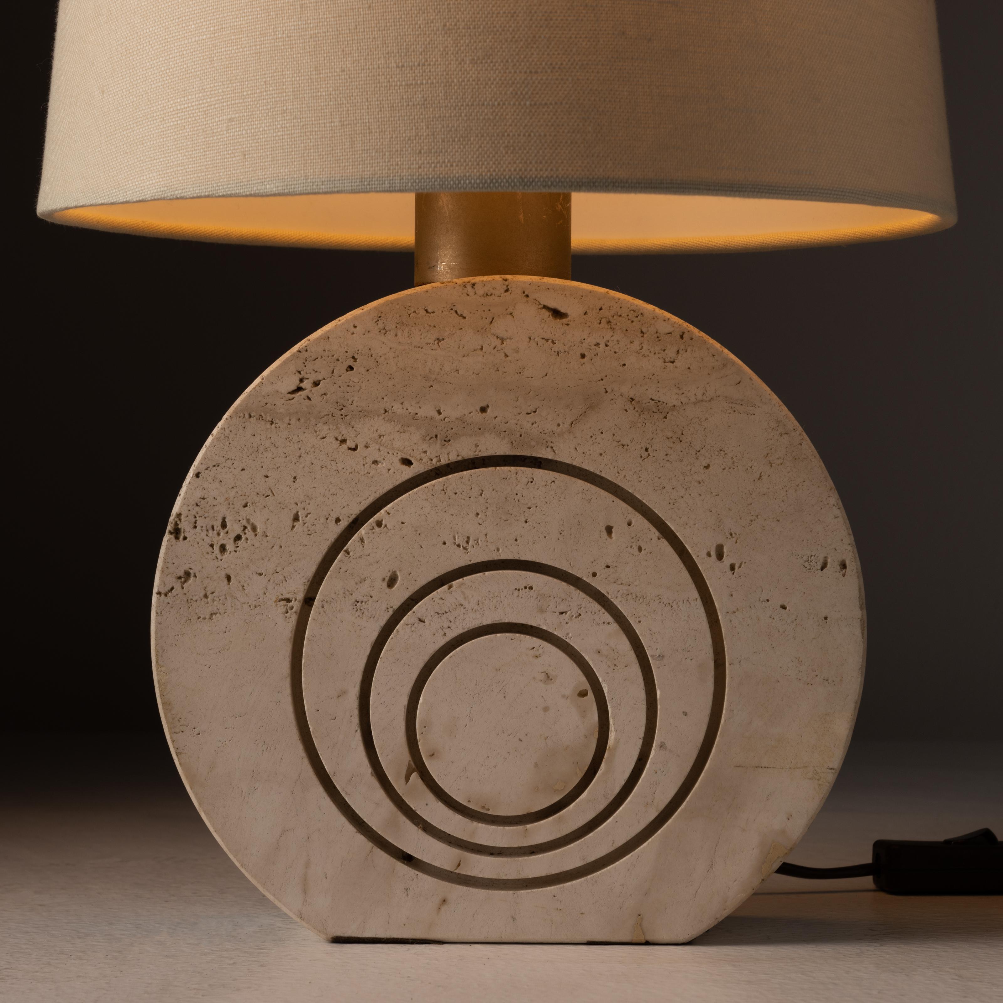 Tischleuchte aus Travertin von Fratelli Mannelli. Entworfen und hergestellt in Italien, um 1970. Einfache Tischlampe aus Travertin mit drei geätzten Kreisen auf der Vorderseite des Lampenfußes. Die Lampe hat eine E27-Glühbirnenfassung, die für die