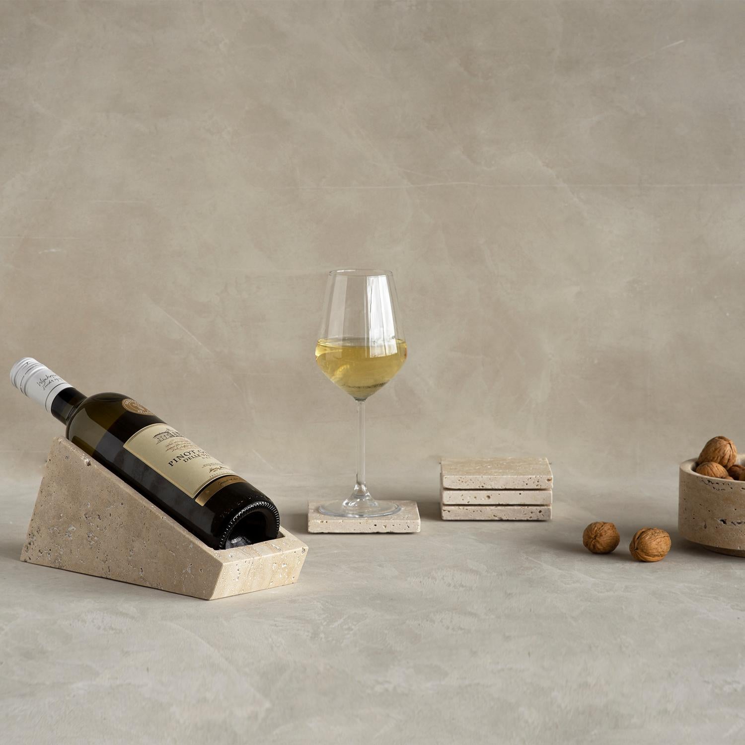 Ponga su vino en un estilo. Fabricado enteramente en travertino, este soporte para vino es una bonita forma de colocar su botella de vino favorita en la encimera de la cocina o en la mesa, y es lo suficientemente llamativo como para funcionar como