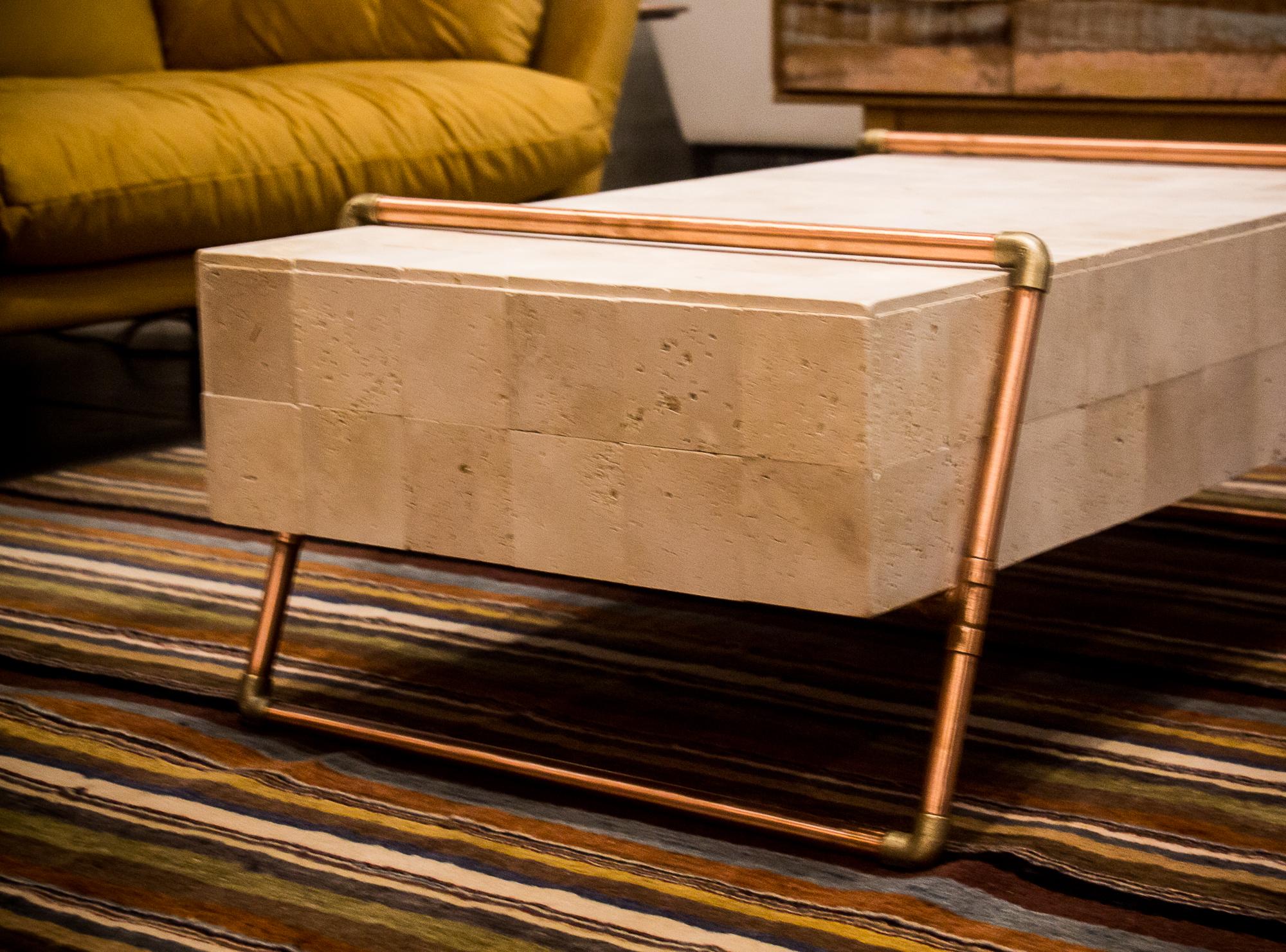 Made of copper, travertine Mable and wood, the Monolito vcenter table has a Minimalist design.