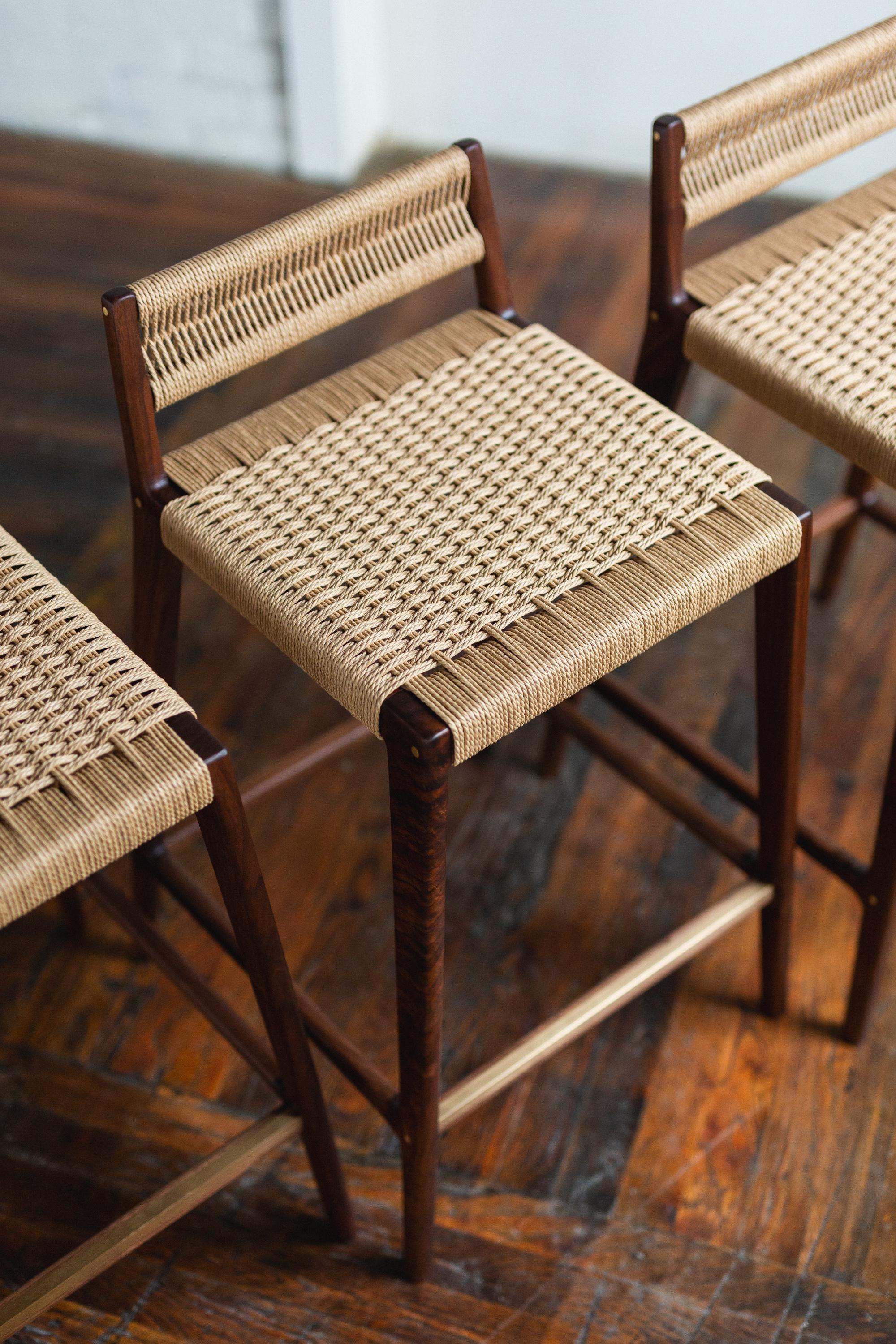 Clean, modern angles complimented by the warm texture of the Danish cord. The Travis stool can be made counter-height or bar-height with different back heights. Shown here in low back with the optional brass leg rest inlay.

All wood construction