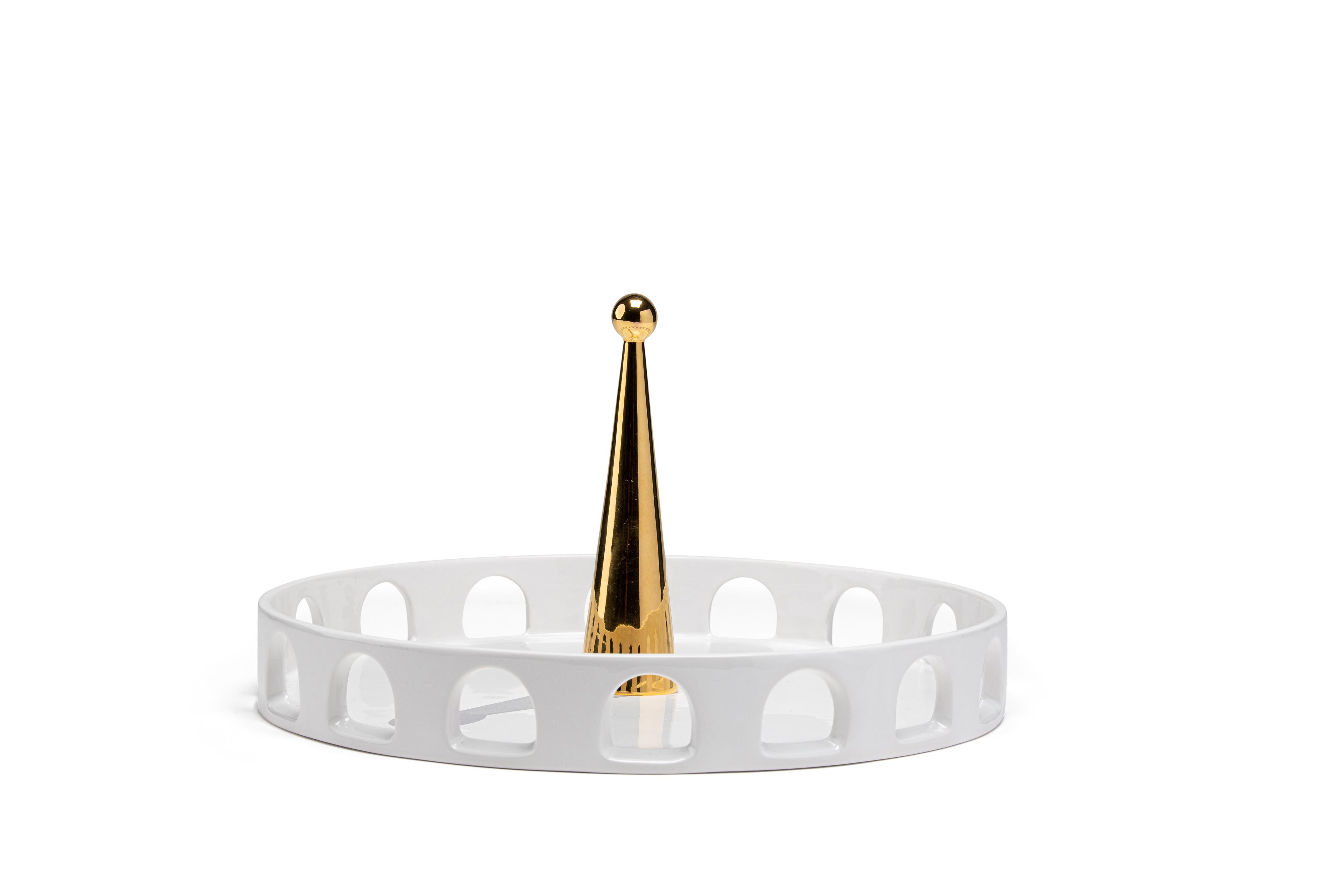 The tray 06:45 of the 'Meridiane' collection recalls typical shapes of Classic Italian architecture. The white ceramic arena is the background for an obelisk painted in 24-karat gold that casts its shadow which is painted on the horizontal