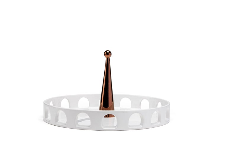 The tray 06:45 of the 'Meridiane' collection recalls typical shapes of Classic Italian architecture. The white ceramic arena is the background for an obelisk painted in copper that casts its shadow which is painted on the horizontal surface.
This