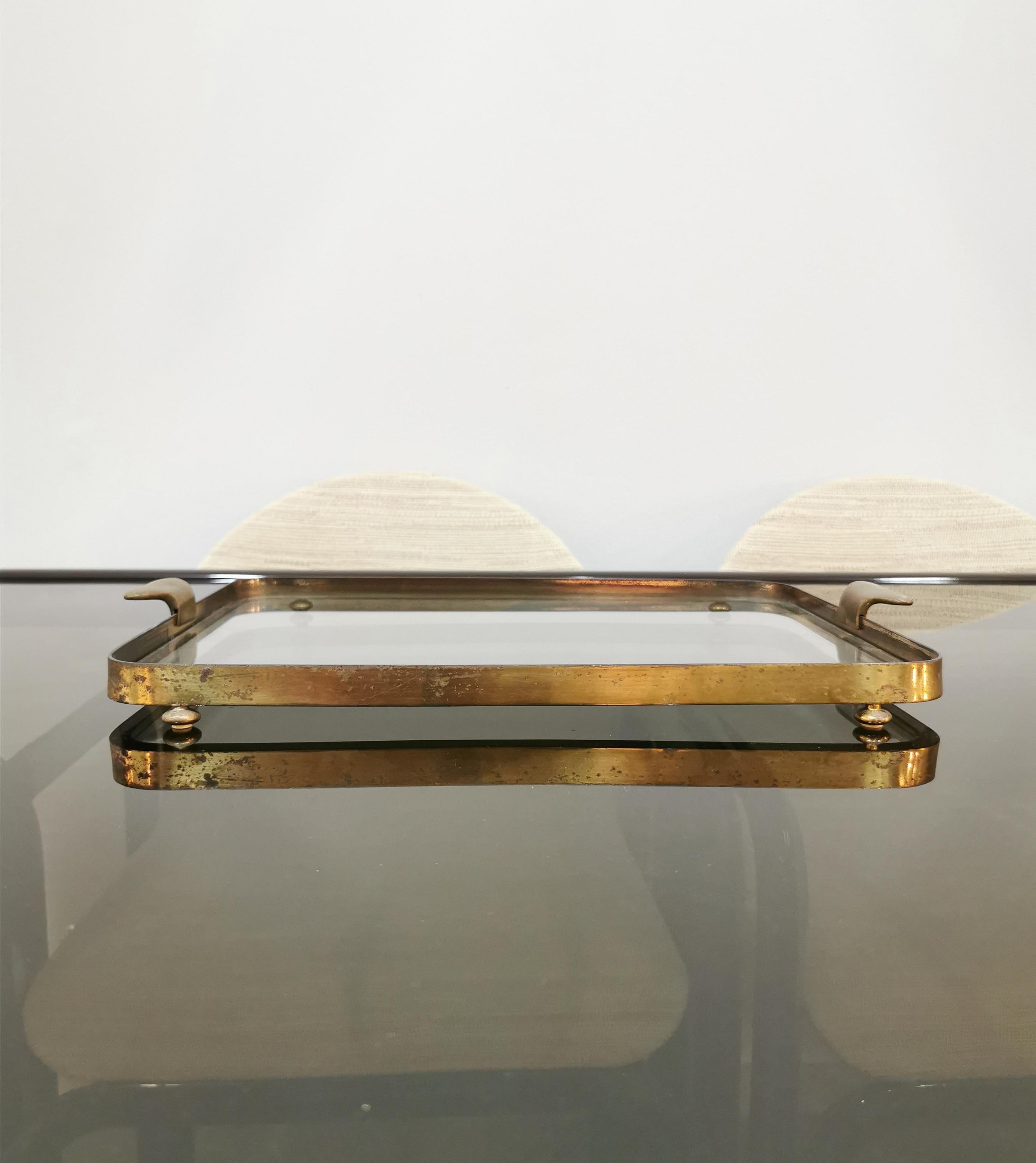 Elegant serving tray in brass, with handles, 4 supporting feet and glass. Italian production of the 1950s.