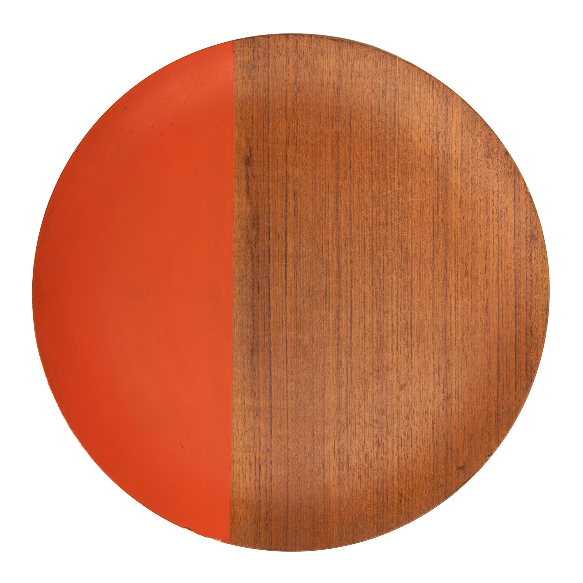 A walnut tray or charger, partially lacquered in vibrant orange.