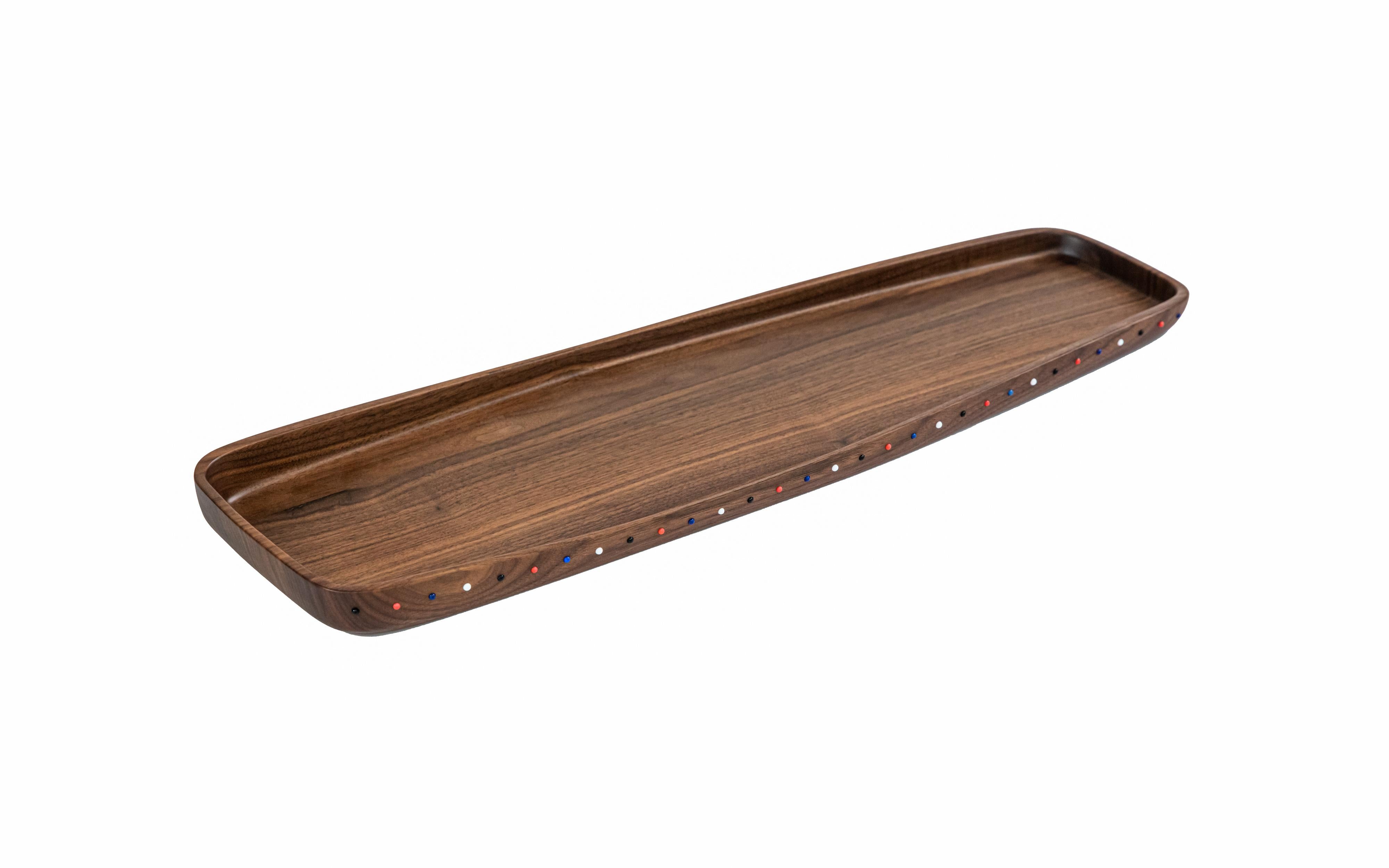 This organically shaped serving tray is carved from one solid piece of walnut wood and embedded with hand-placed glass pearl bead ornamentation. It can also be used as a platter or table centrepiece. 

The Pok collection celebrates the artistry of