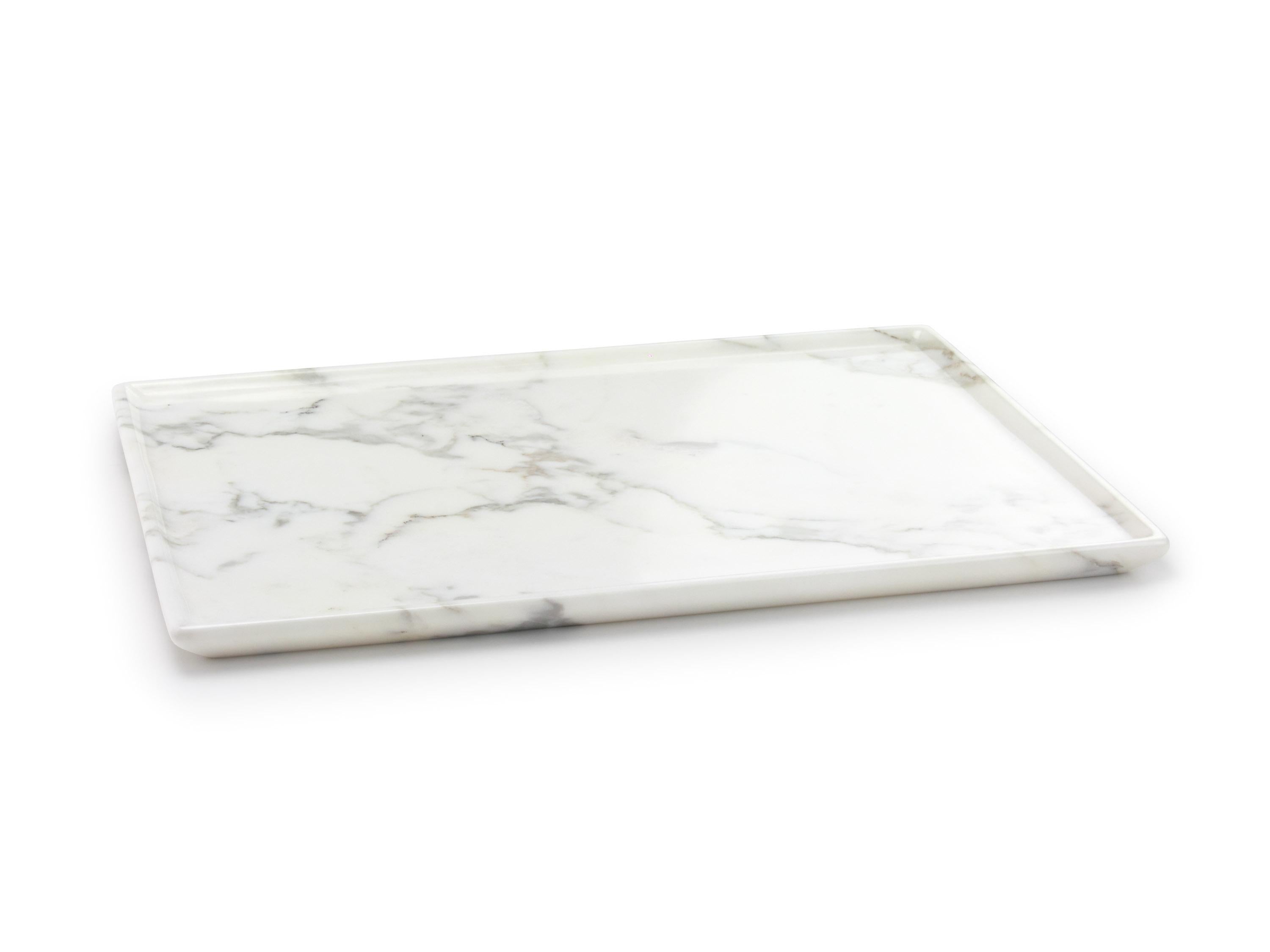 Tabletts oder Servierplatten, die von Hand aus einem massiven Block aus weißem Calacatta-Marmor geschnitzt werden. Abmessungen des Tabletts: L 40, B 29,5, H 2 cm, erhältlich in verschiedenen Marmorsorten und Onyx.

Marmor ist ein natürliches