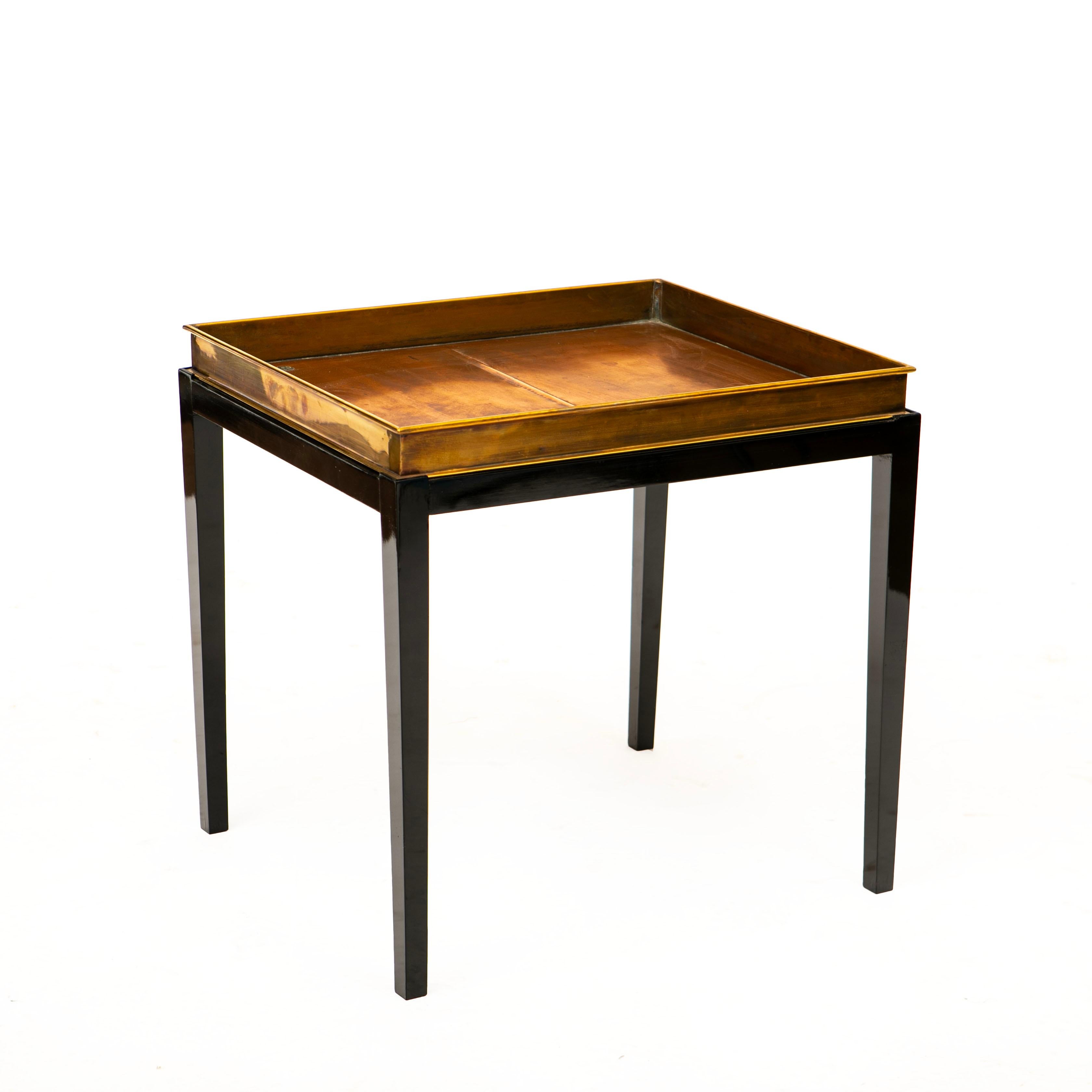 Tray table in brass and copper 
Placed on a black polished mahogany base.
The tray is an old beer tray .

Denmark approx. 1950.