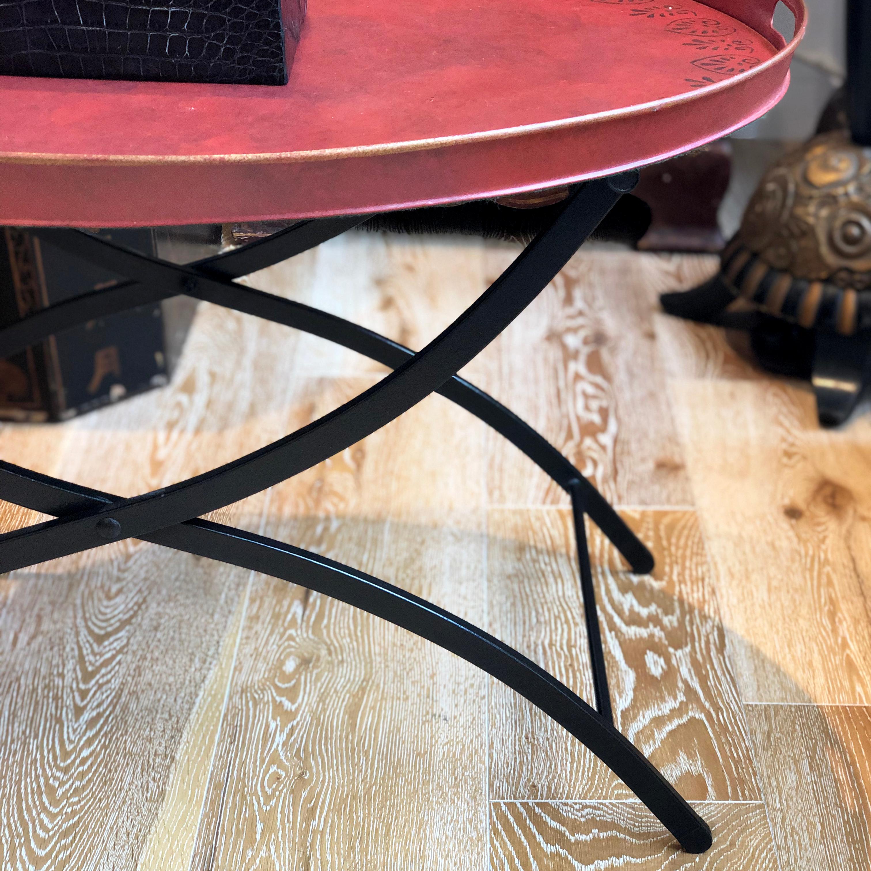 Red metal tray table with black foldable stand. Unique oval side table with a decorative black stencil edge.

Measures: 81 W x 64 D x 52 H cm

Good vintage condition considering the age.