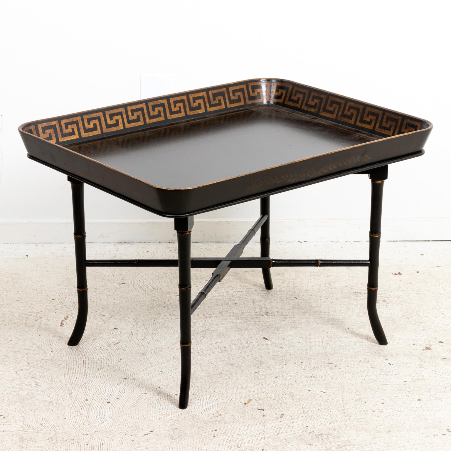 Decorative tray table for drinks or coffee detailed with Greek Key trim as seen on the inside gallery of the tabletop. The table is supported by faux bamboo legs and an x-shaped cross stretcher. Please note of wear consistent with age including