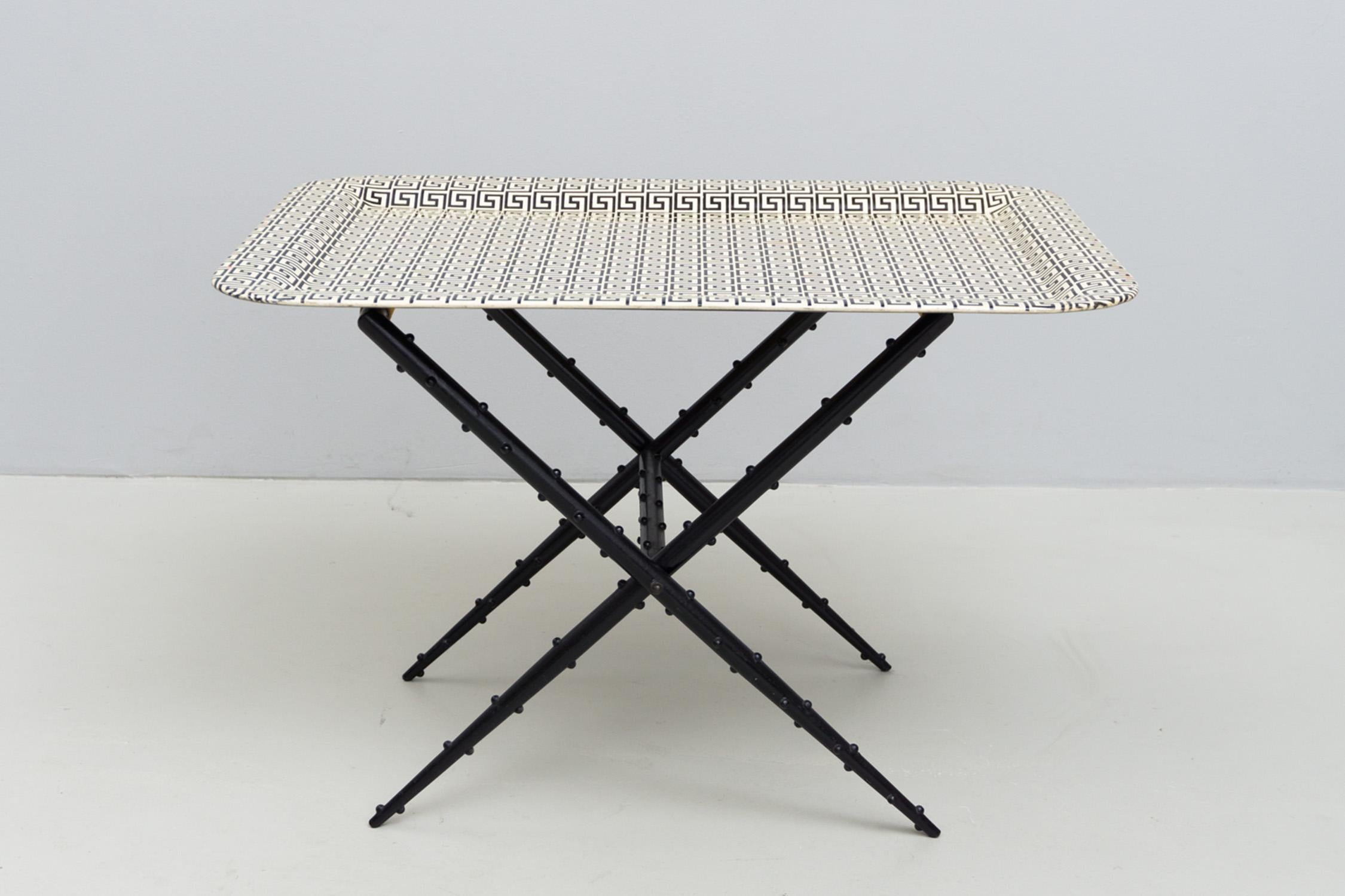 Extravagant tray table with a foldable structure made of enameled metal. Beautiful golden textile ribbons hold the printed tray. Tray in black and eggshell. Designed by Piero Fornasetti, 1950

Piero Fornasetti (Milan, 10 November 1913 - 15 October