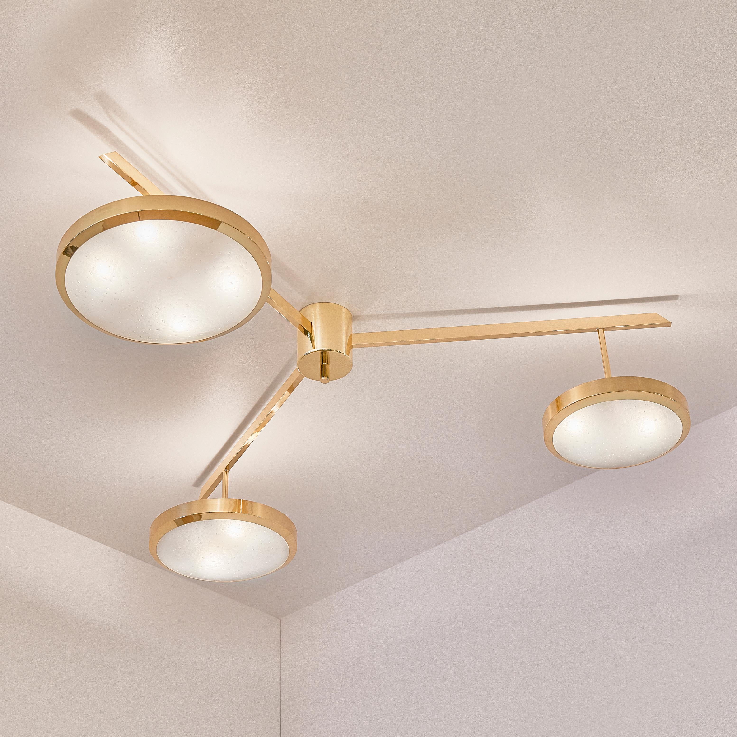 The Tre ceiling light harmoniously juxtaposes the balance of its three evenly spaced arms with the asymmetry of its variable size shades staggered at different heights. The first images show the fixture in our polished brass finish-subsequent