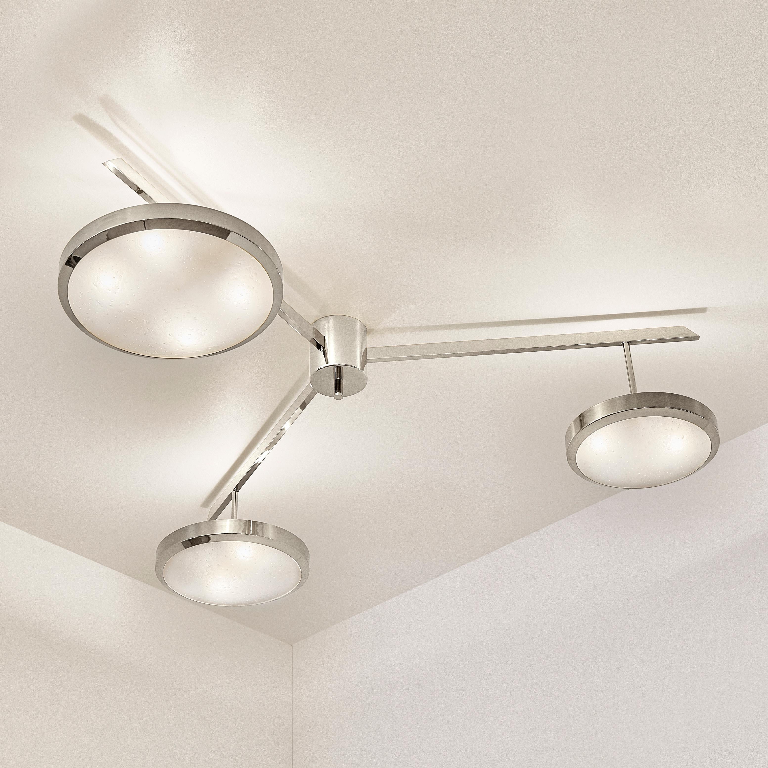 The Tre ceiling light harmoniously juxtaposes the balance of its three evenly spaced arms with the asymmetry of its variable size shades staggered at different heights. The first images show the fixture in our polished nickel finish-subsequent