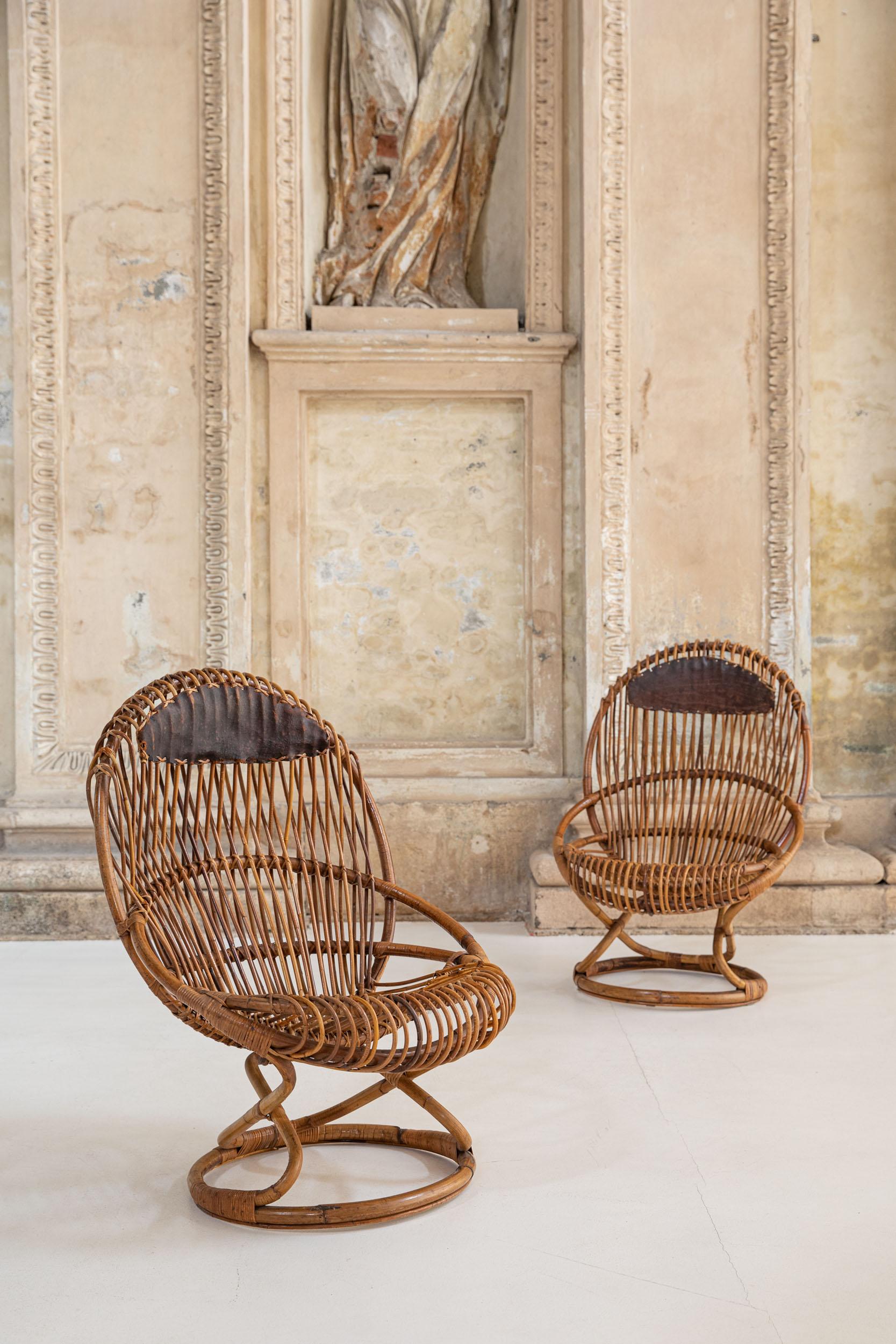 Couple of rattan armchairs designed by Tito Agnoli for Bonacina in the 1950s. This chairs have been master handcrafted with natural materials of high quality and have an amazing design, very comfortable seating. 
Original leather.