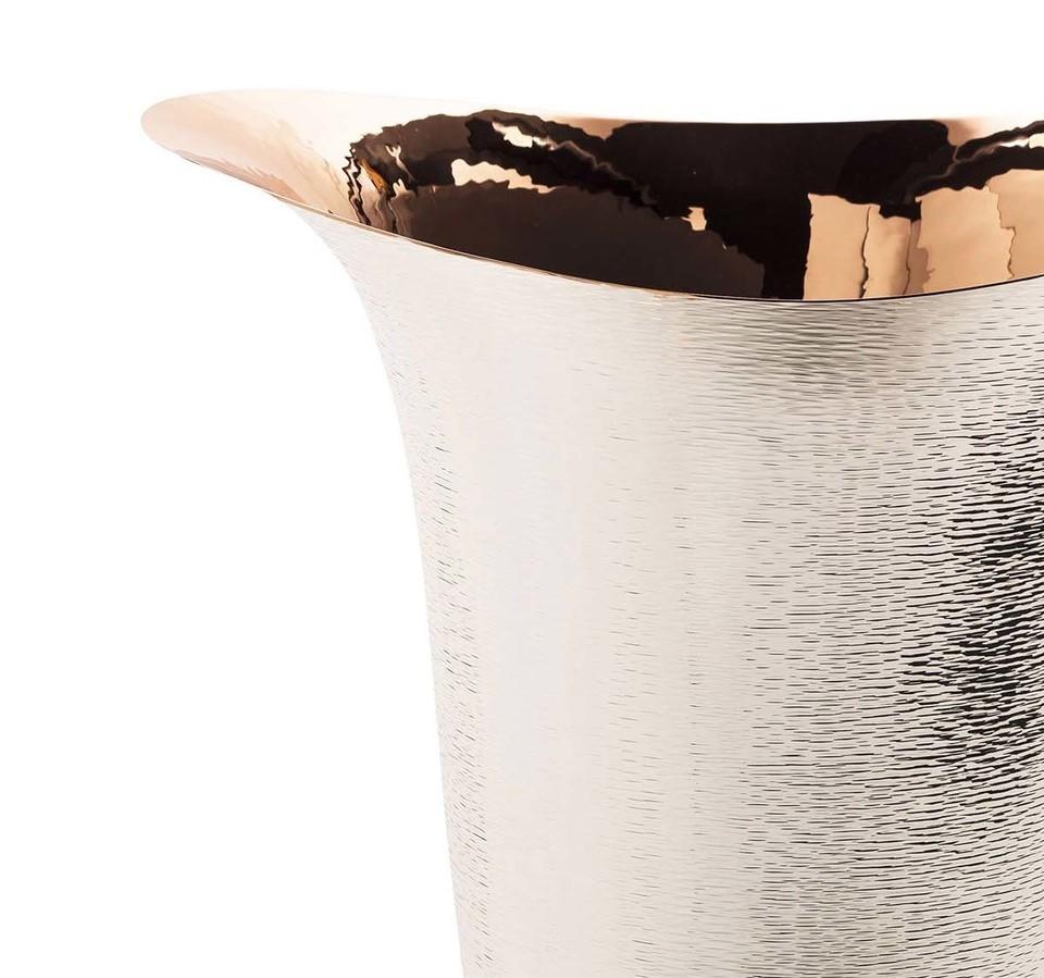 A sculptural work of art, this splendid vase boasts a strong visual impact, thanks to the combination of two refined materials such as silver and copper. The supporting three-tiered square base and the shiny interior are made of copper, while the