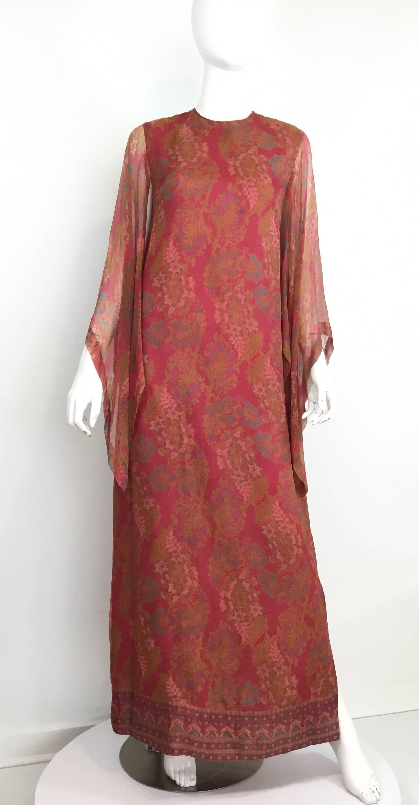 Treacy Lowe caftan featured in dusty rose and subtle multicolored print throughout a delicate silk chiffon. Caftan has short sleeves with a cape layered over the shoulders, back zipper fastening, and an optional scarf tie. Made in England. UK size