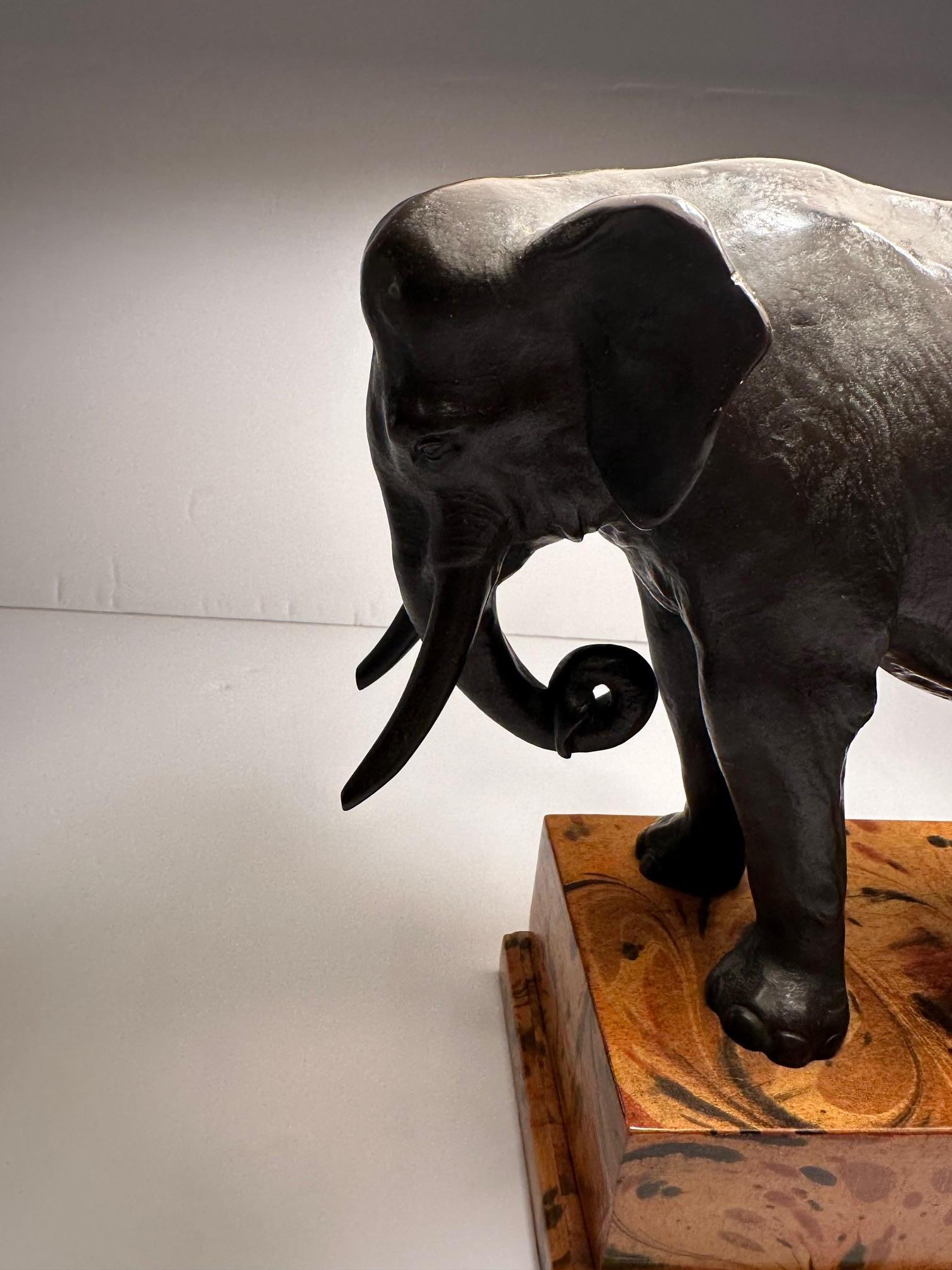 Gorgeous and classy bronze sculptural elephant on faux painted wooden base creating a luxurious table lamp.  Custom paper shade.
Lamp is 11 w 5 d
Shade is 14 x 10 . 8.5 d