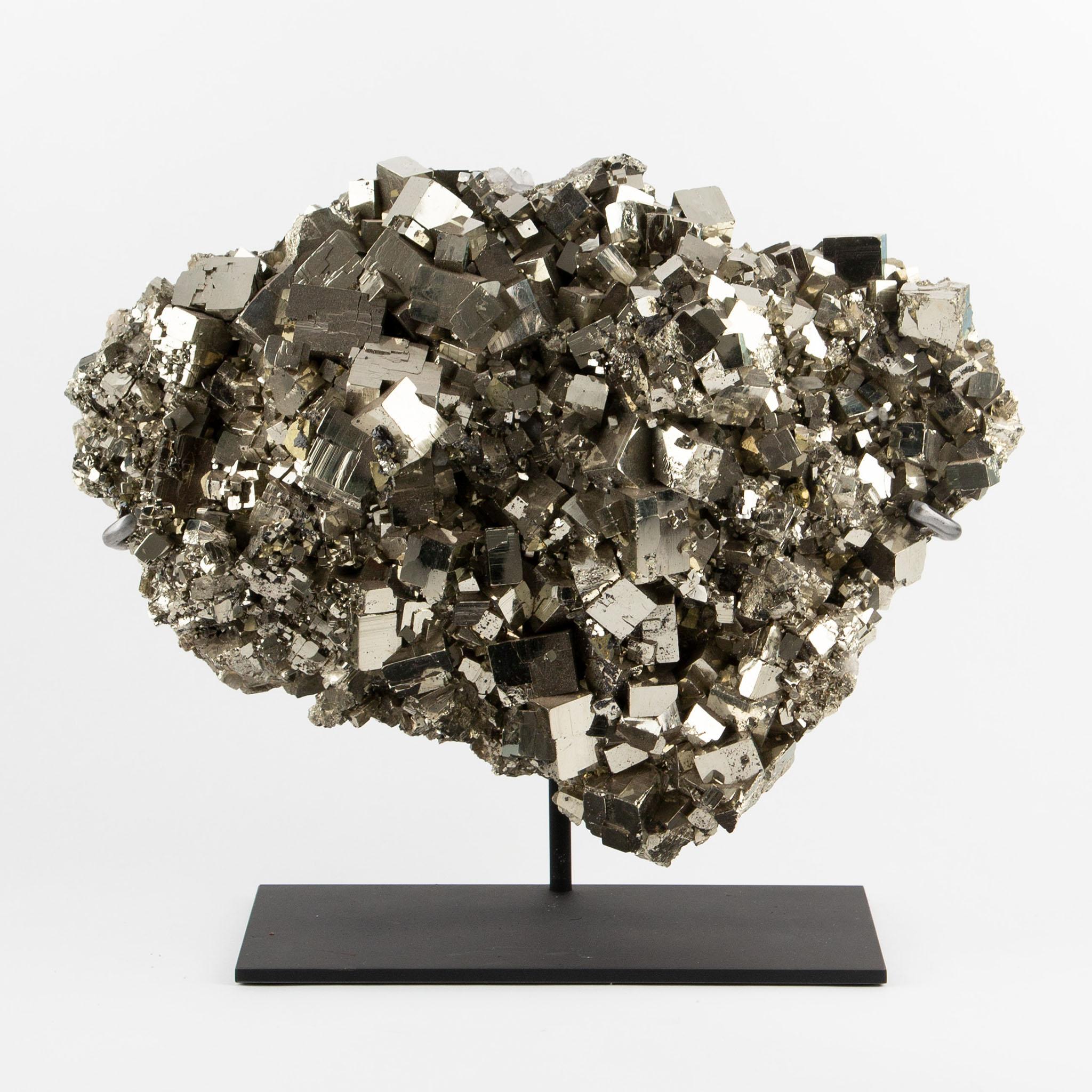 Grande gruppo di pirite montato con cristalli cubici densamente impacchettati e formati naturalmente con una straordinaria lucentezza metallica, caratteristica degli esemplari di pirite più pregiati. Le facce di cristallo intrecciate riflettono la