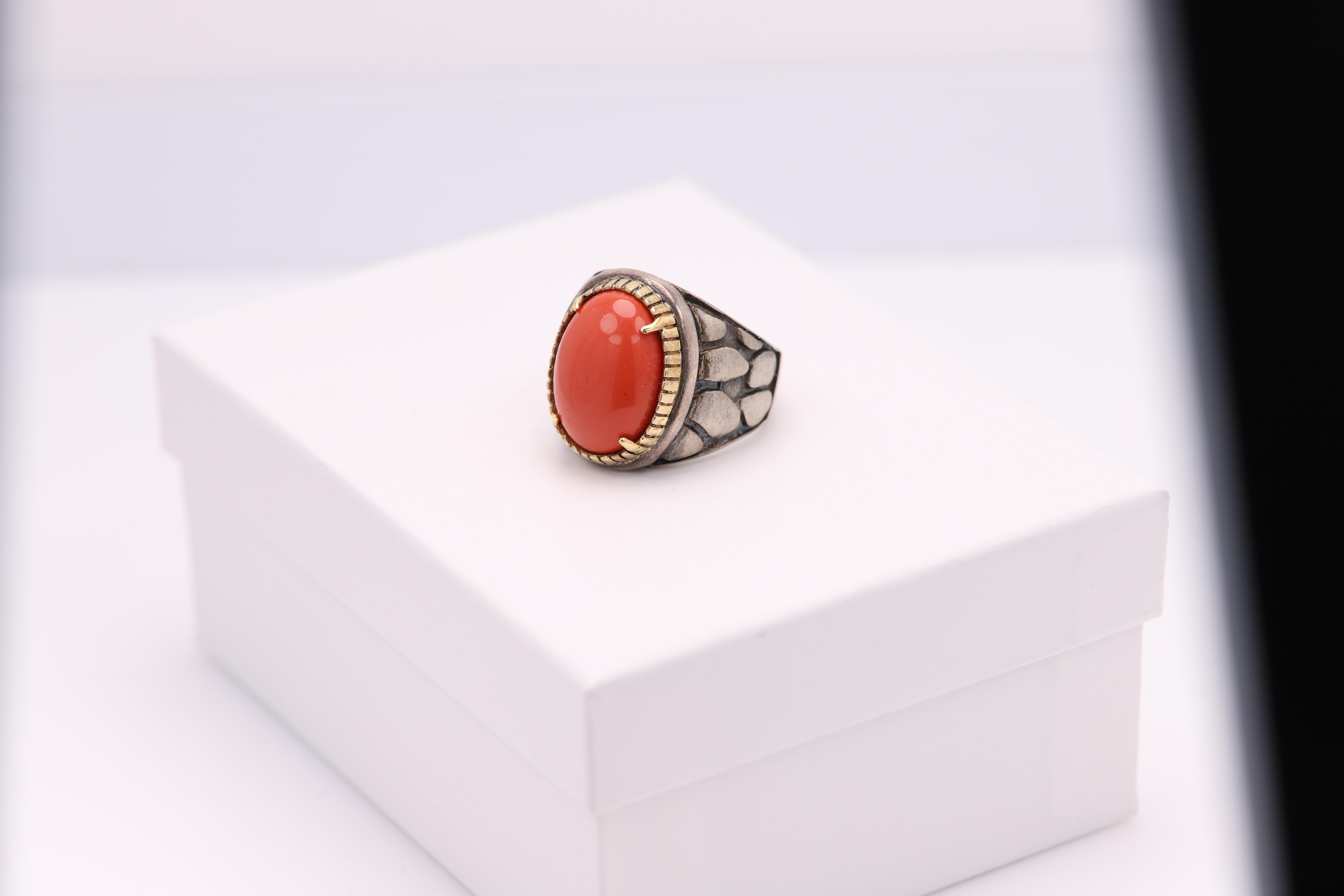 Vintage Ring with a Brilliant Treated Coral stone
Cabochon cut.
The stone is natural but treated with color(it is and was common to do so)
Approx size 21 x 12 mm
Mostly Sterling Silver 925 and the bezel is solid 18k yellow gold.
Well craftsmanship -