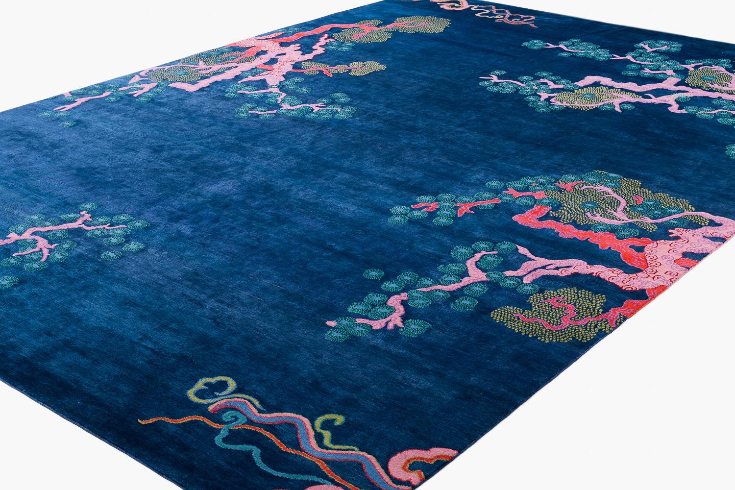 Albero e nuvola è un disegno di Joseph Carini Carpets che rappresenta una delle principali firme di Carini. Questa è la versione indaco, caratterizzata da un fondo blu indaco intenso e ricco con rami rosa e corallo e fiori blu. Ispirato dal suo