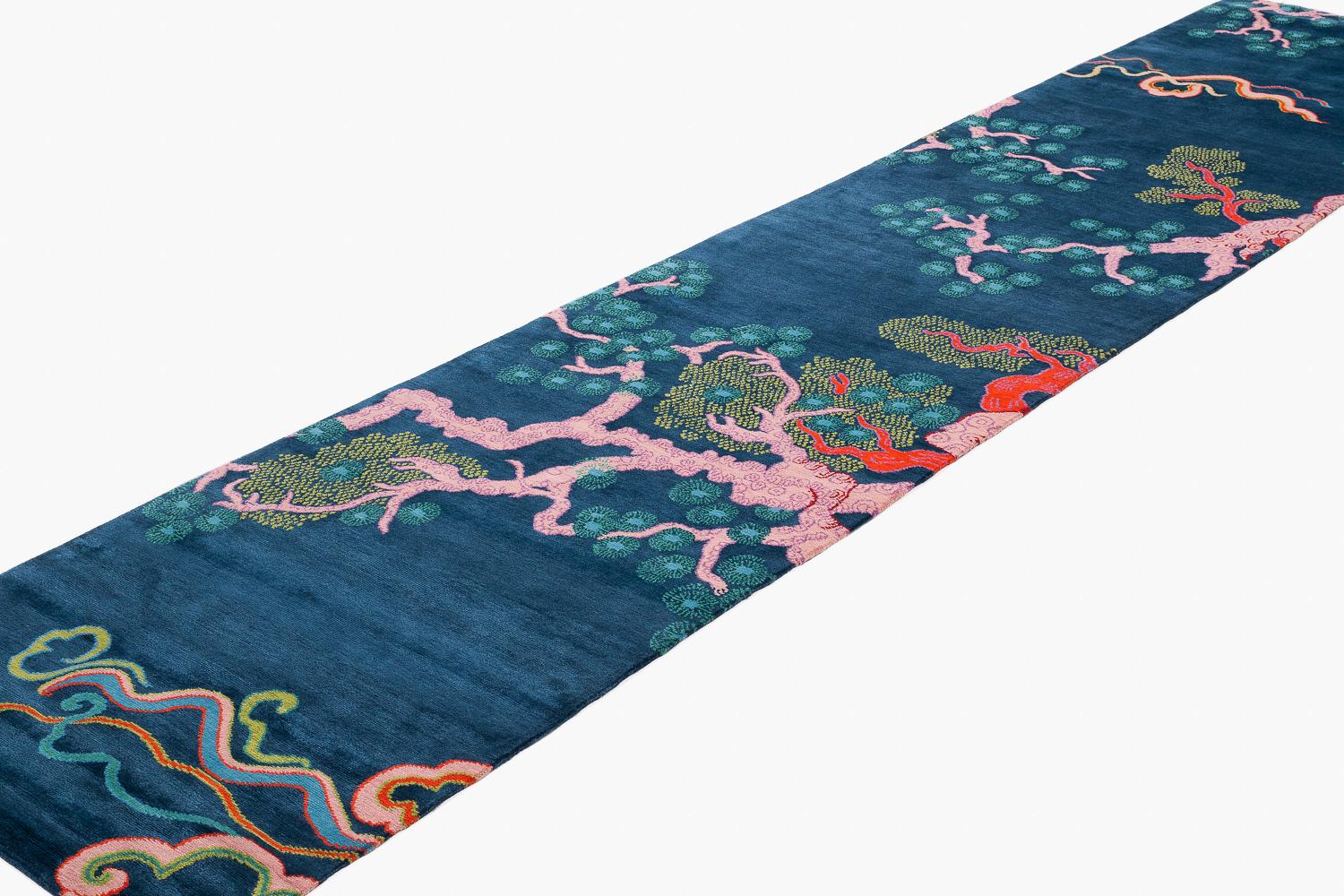 Tree and Cloud is a mainstay Carini Carpets signature design by Joseph Carini. This is the indigo rendition, featuring a deep and rich indigo blue ground with corral and pink branches and blue floral blossoms. Inspired by his love for Chinese art,