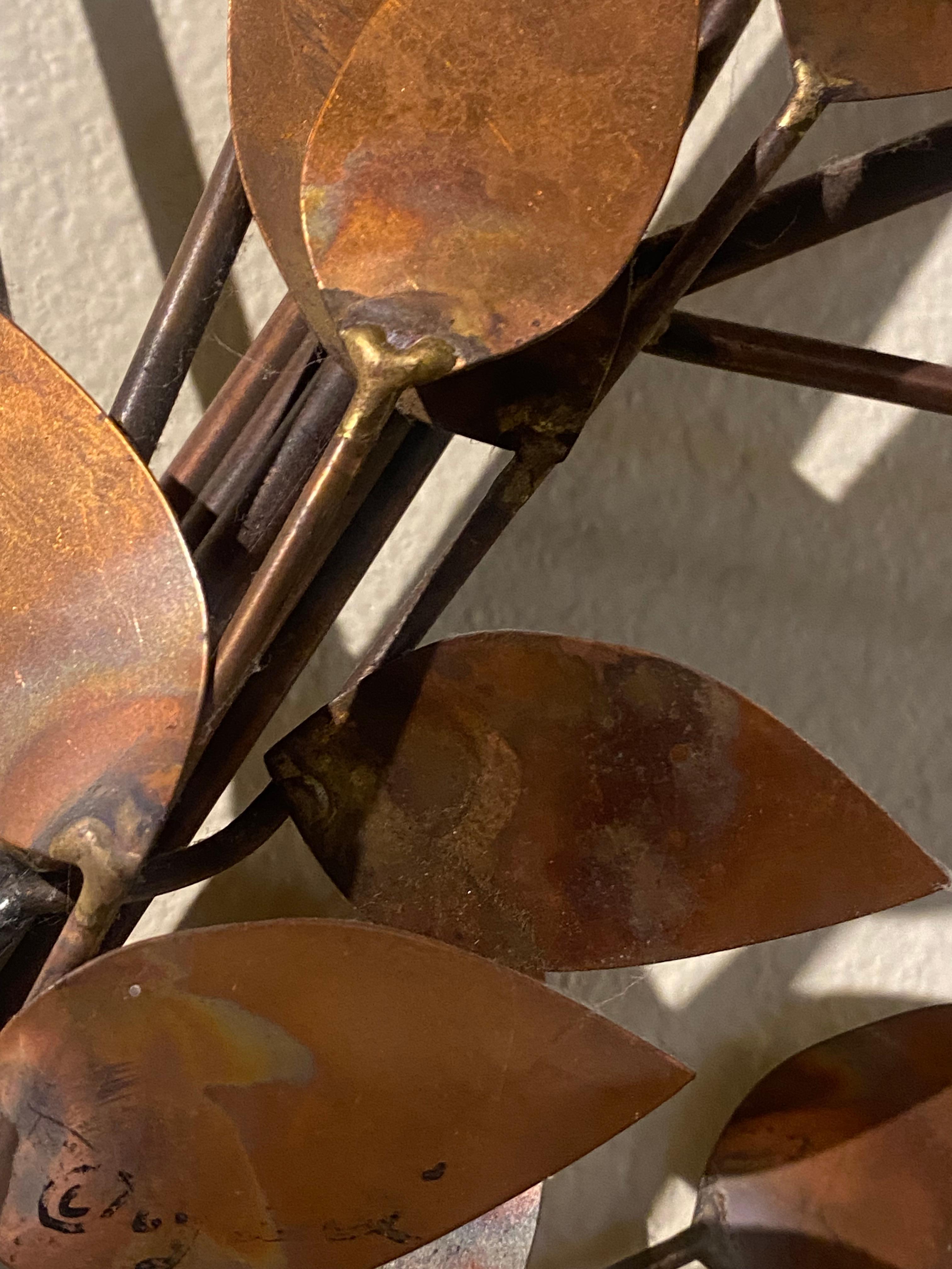 Esta escultura de pared Rama de árbol de Curtis Jeré para Artisan House es una llamativa composición de arte en metal, con una elegante forma ramificada adornada con hojas de cobre. A diferencia de las interpretaciones más geométricas de la obra de