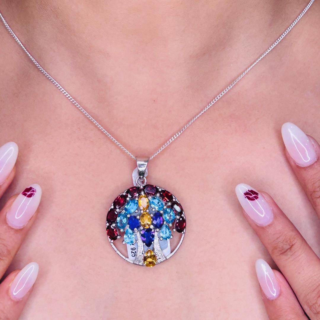 Colgante Árbol de la Vida Círculo Multigema de Plata de Ley 925 en plata de ley tachonada con multigema de talla redonda. Esta impresionante pieza de joyería eleva al instante un look informal o un conjunto de vestir. 
La Gema Multi aumenta la