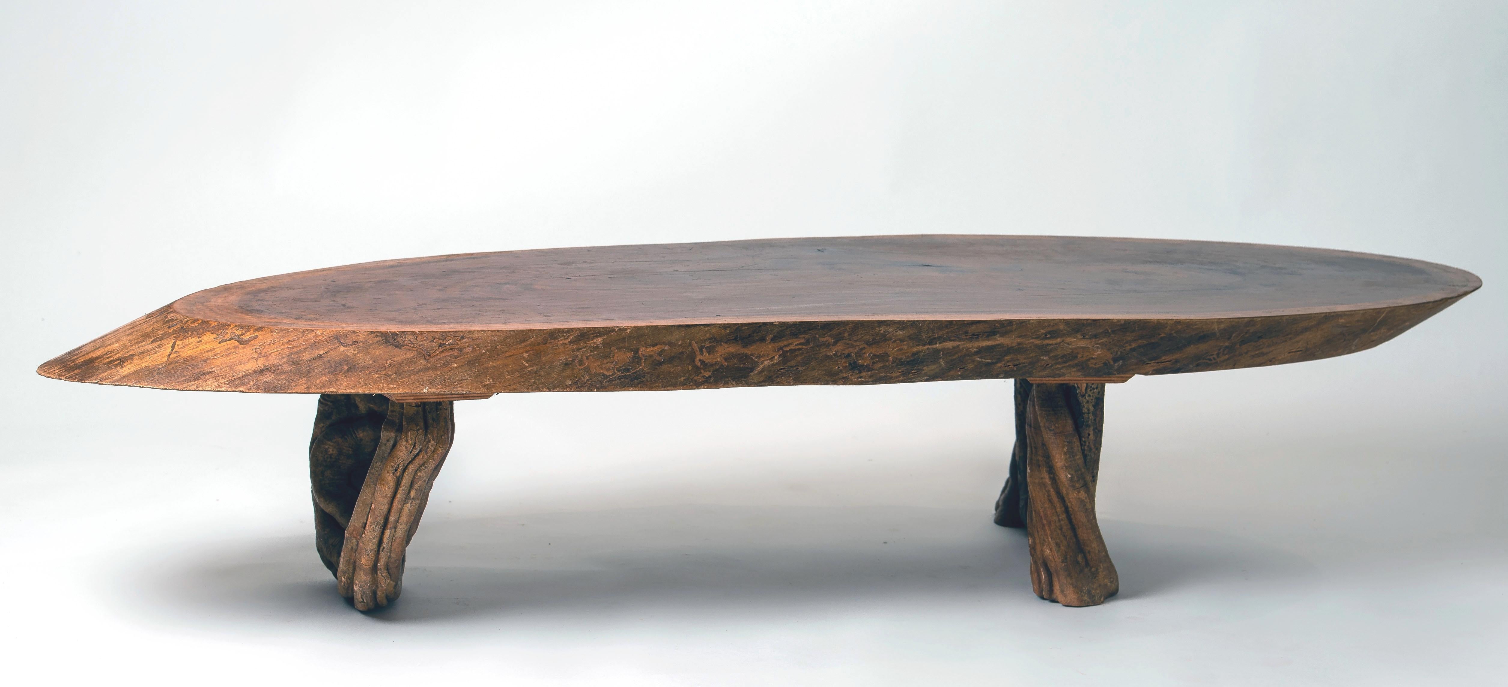 Extra large coffee table, top made of a thick slice of a tree and a base made of liana.
 