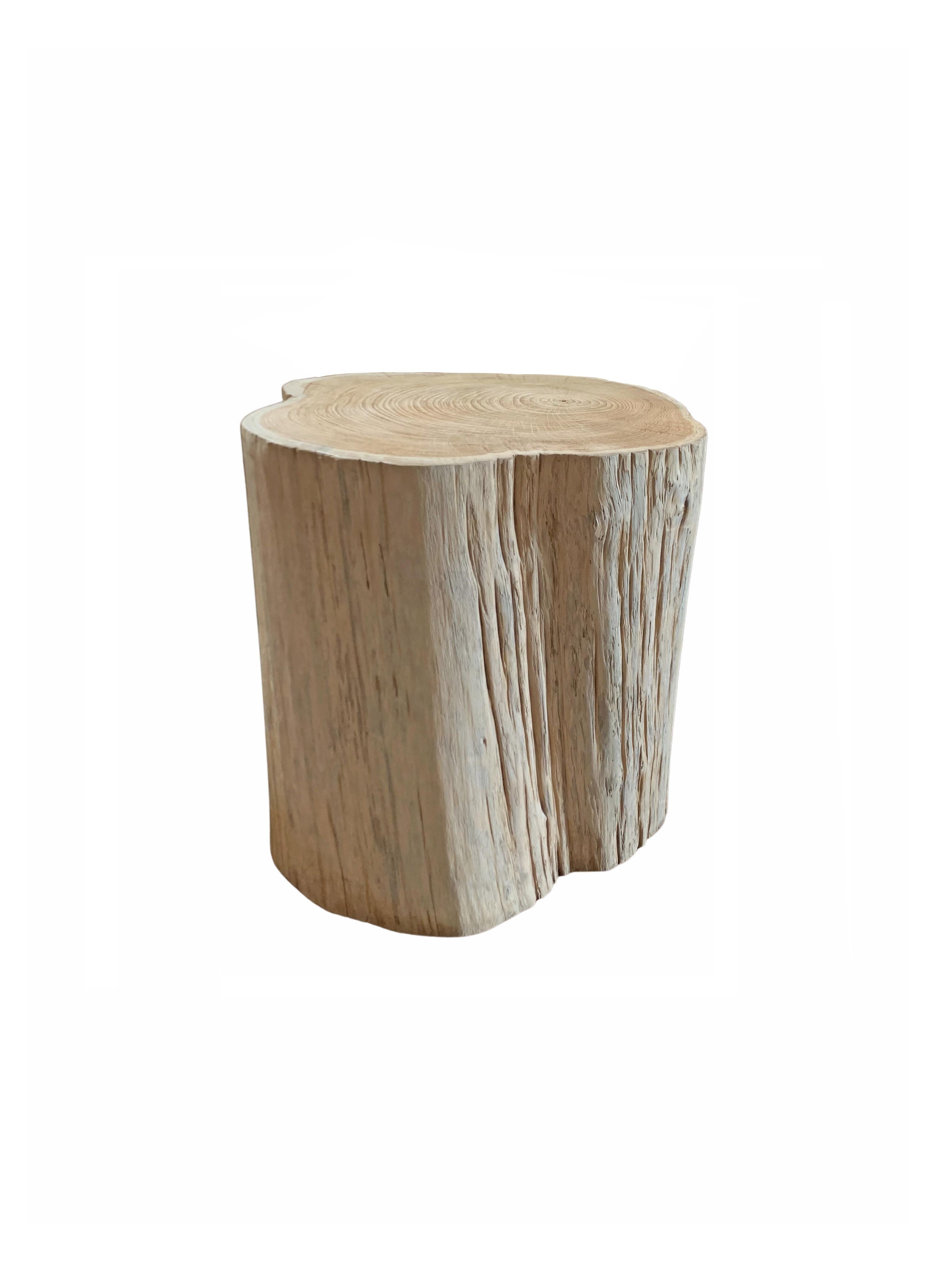 A wonderfully organic round side table. Its neutral pigment and subtle wood texture makes it perfect for any space. This table was crafted from a solid trunk of mango wood. To achieve its pigment the wood underwent a bleaching process and was then