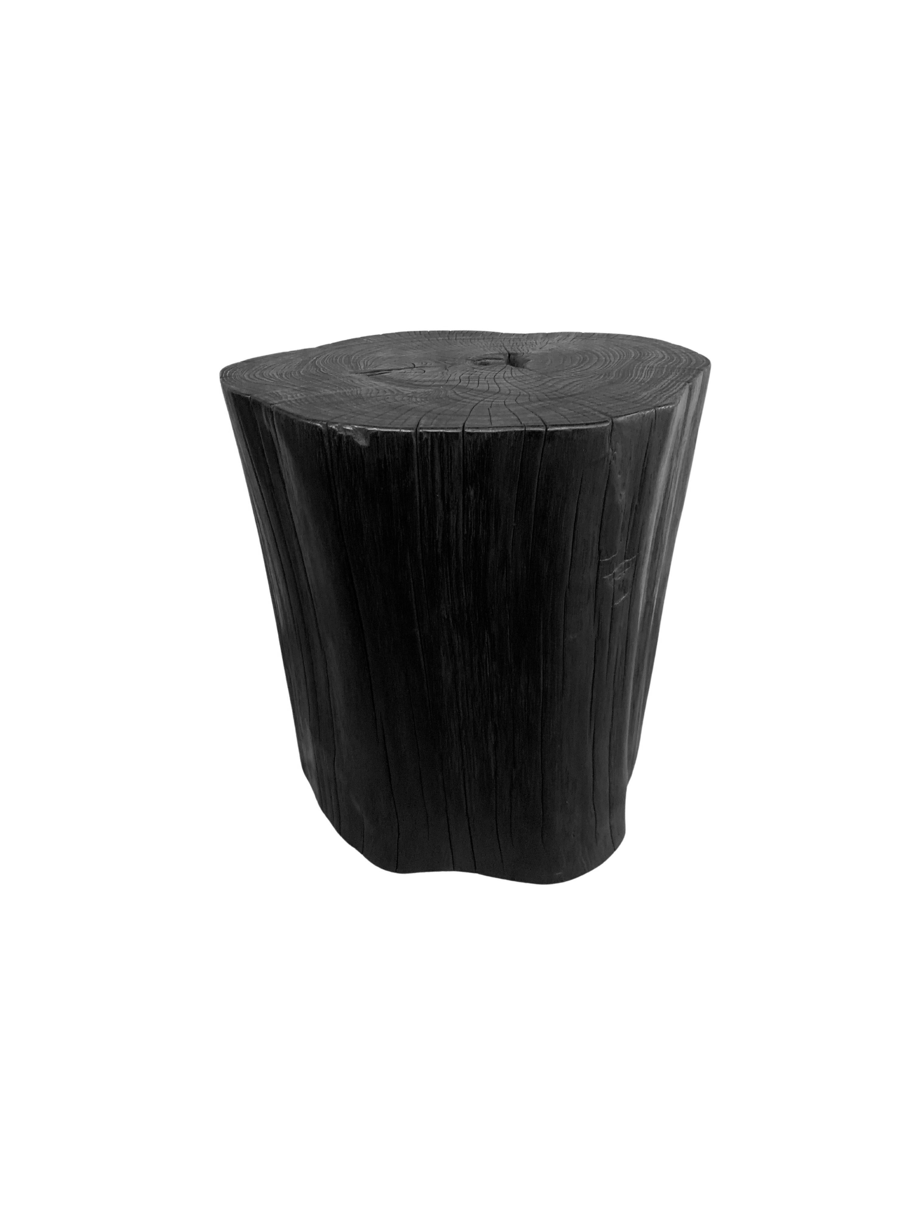 A wonderfully organic round side table. Its neutral pigment and subtle wood texture makes it perfect for any space. This table was crafted from a solid trunk of teak wood. To achieve its pigment the wood was burnt numerous times and then finished