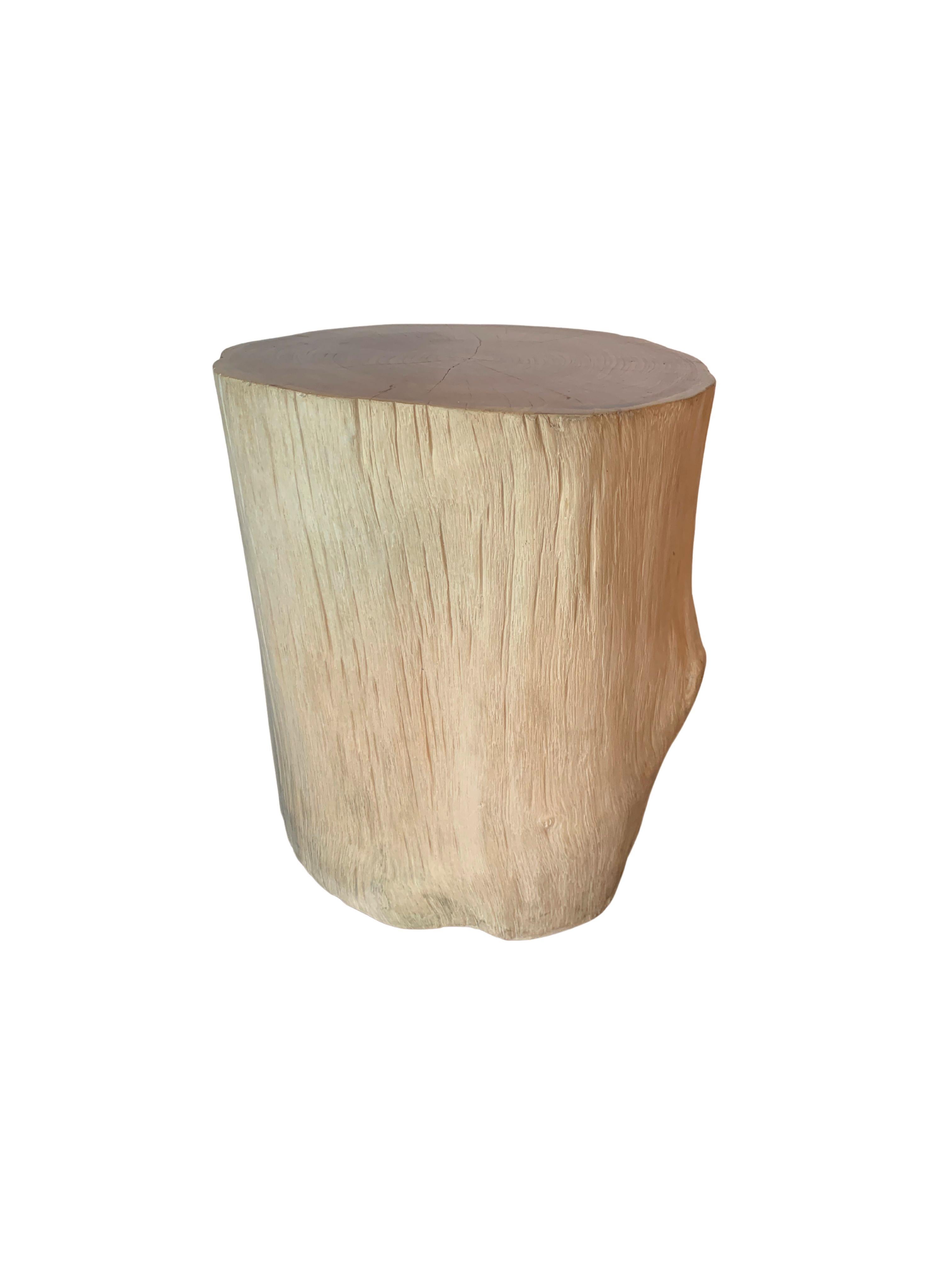 A wonderfully organic round side table. Its neutral pigment and subtle wood texture makes it perfect for any space. This table was crafted from a solid trunk of teak wood. To achieve its pigment the wood was bleached on its sides numerous times and
