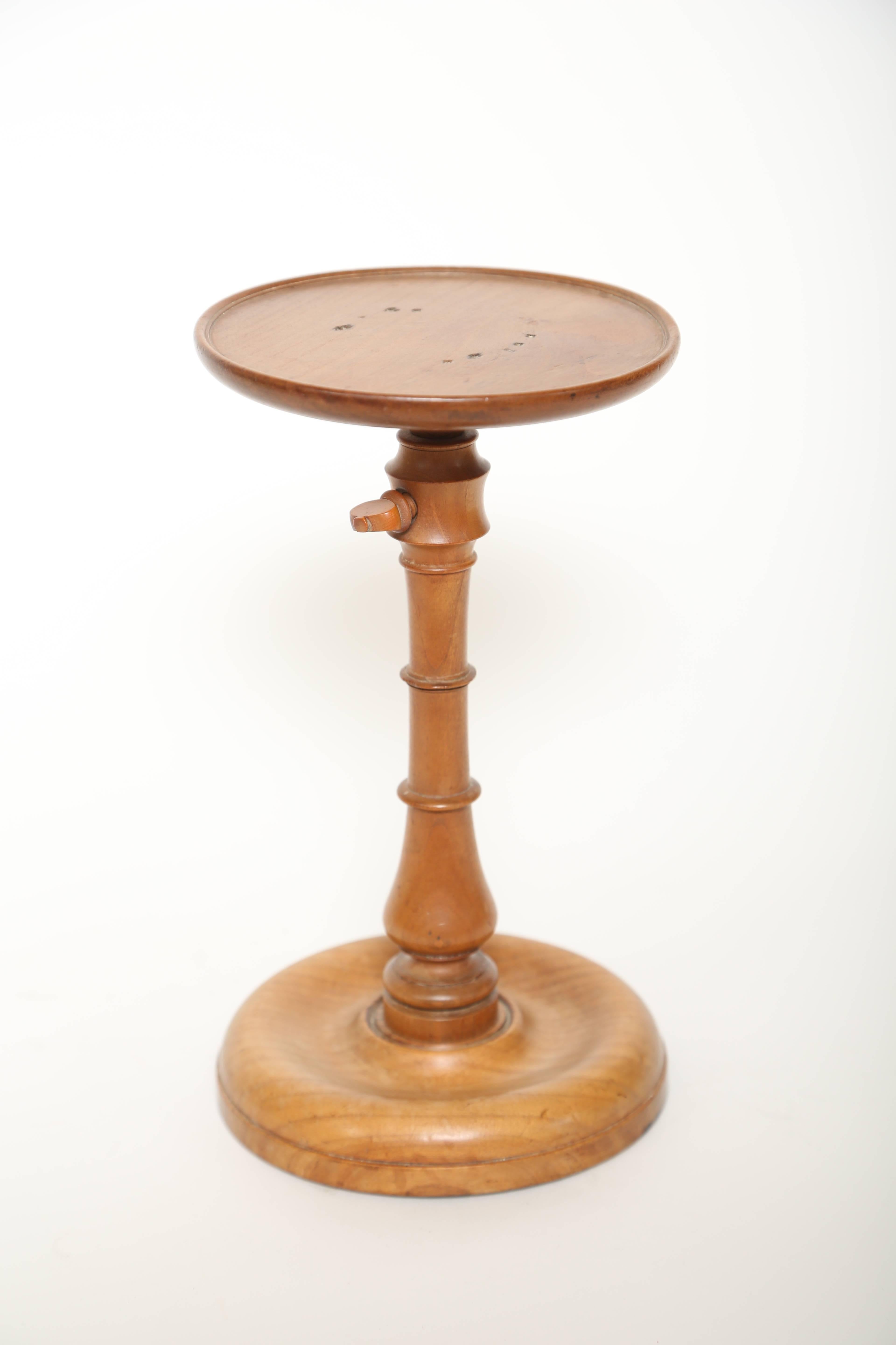 Hand lathe turned adjustable and lead weighted candle stand. It adjusts easily with a turn screw on the side. This example is unusual to find in a light color, as they were more typically made in mahogany. Wonderful patina.
The candle stand adjusts