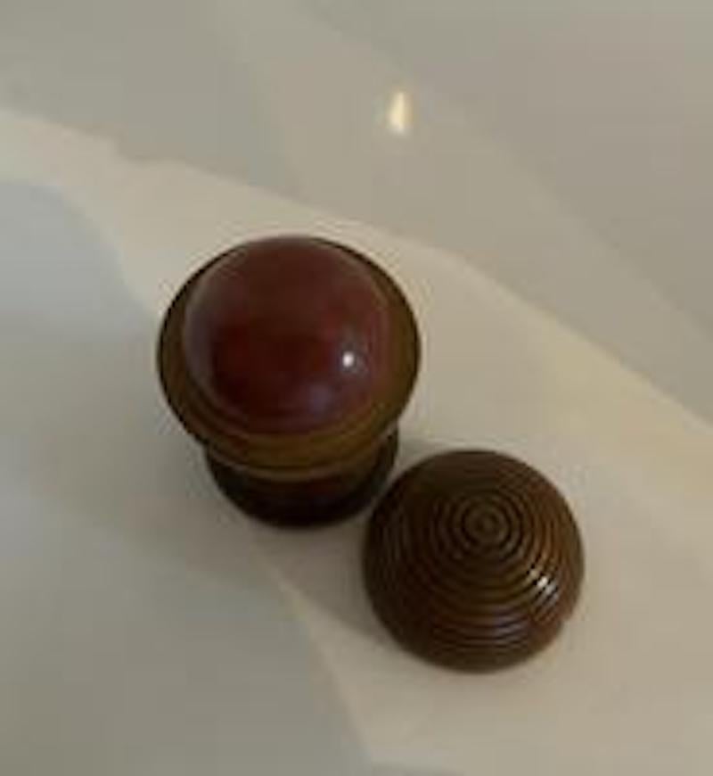 This English nineteenth century item is referred to as a treen disappearing ball trick.  It is made from boxwood and has two tops.  One would lift the first top to reveal a half ball fixed to the base.  The second top lifts to reveal a full ball. 