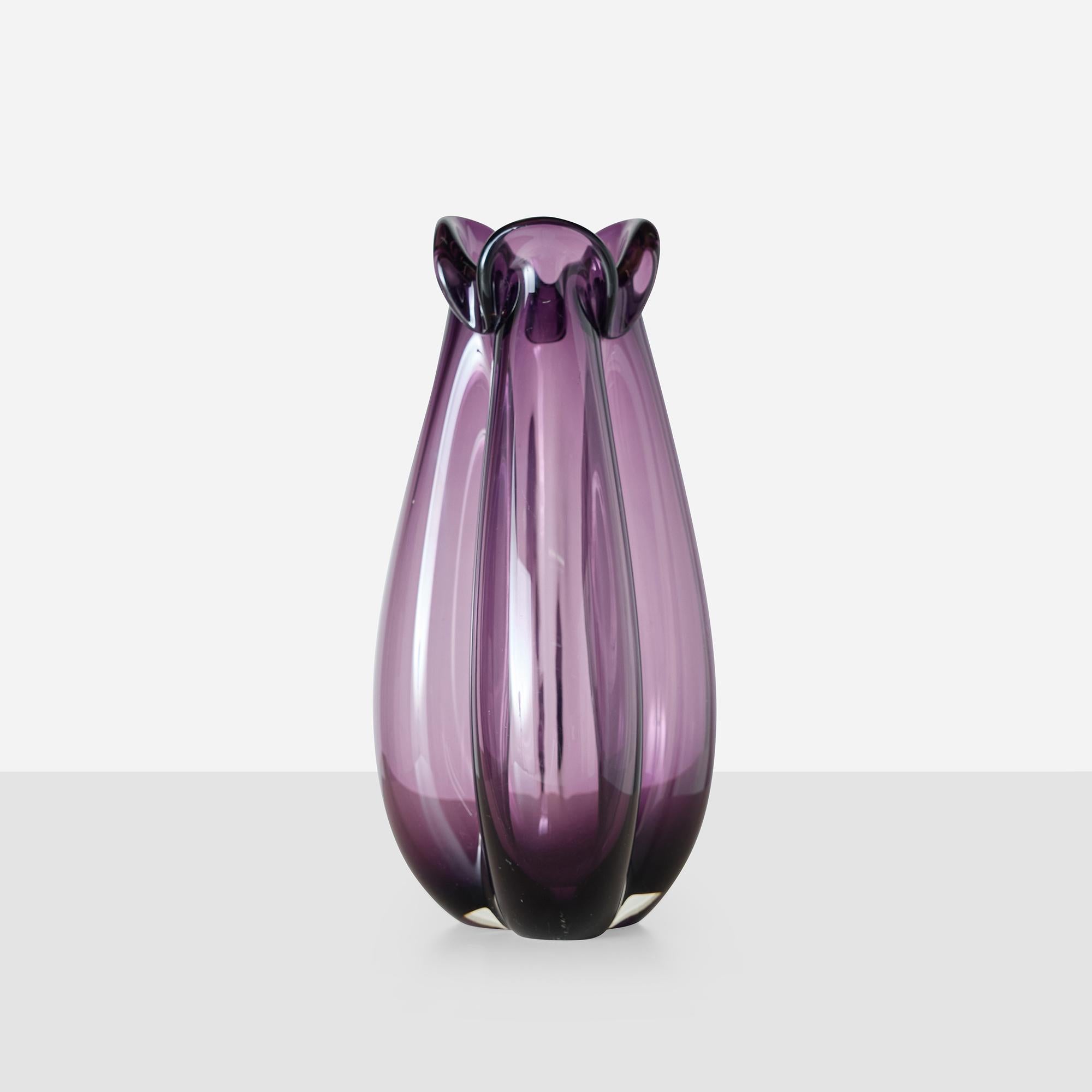 Vase en verre améthyste soufflé à la bouche avec une forme trilobée caractéristique. Fait partie d'une série produite en plusieurs formats à partir de 1955. Gravé 