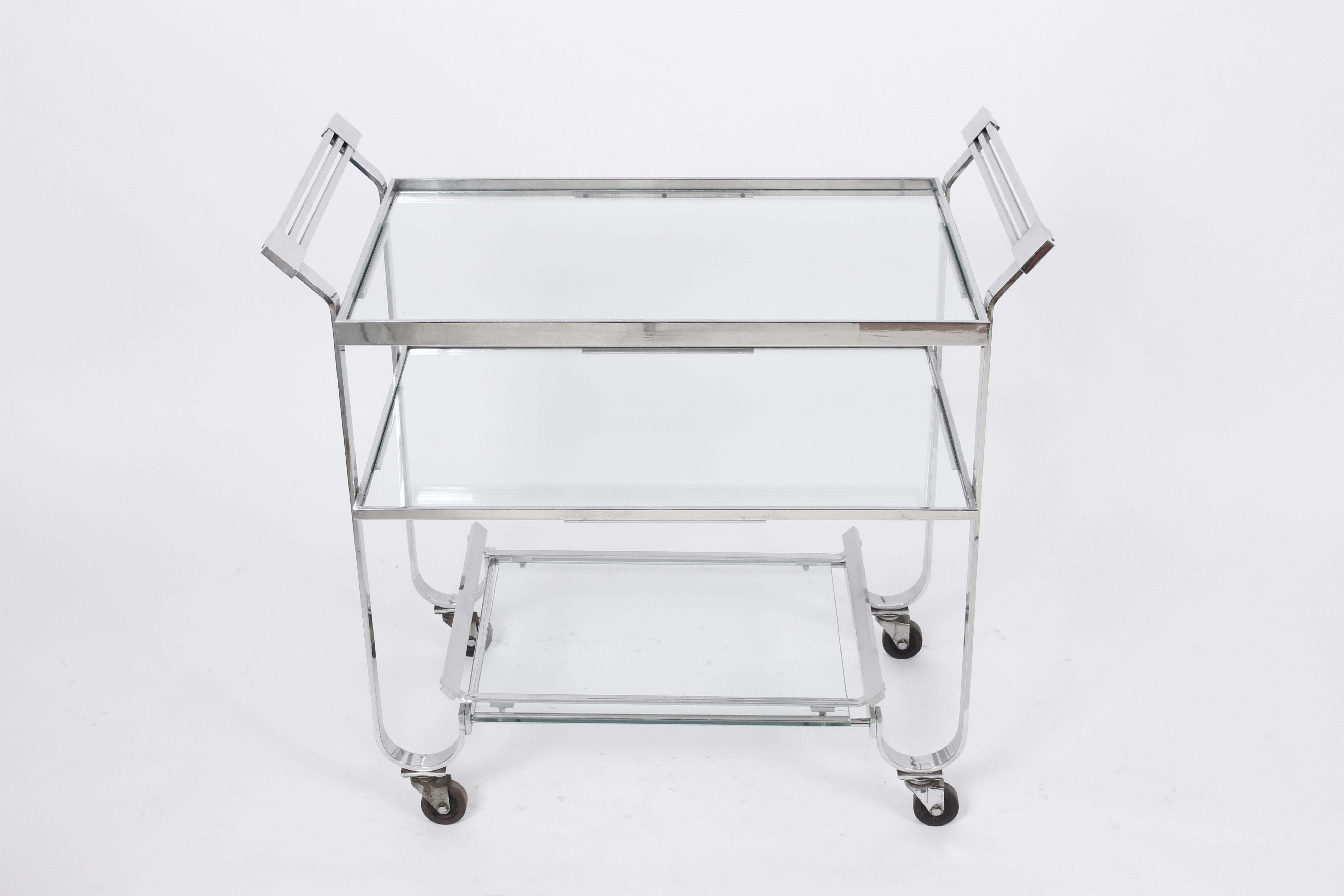 Classic Treitel-Gratz New York Art Deco bar cart - tea trolley - serving cart with removable lower serving tray. Featuring a lipped, rectangular reflective Chrome plated Brass frame with three recessed glass shelves, lower tray removes for serving,