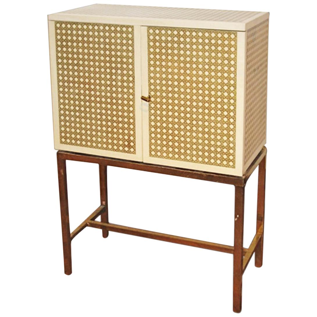 Sophisticated and elegant cabinet on stand, the gilt 'caning' pattern on ivory satin-finished lacquer ground, The cabinet opens to wood interior with on brass legs
With Certificate of Authenticity from the artist
Measures: H 100 cm / W 70 cm / D 35