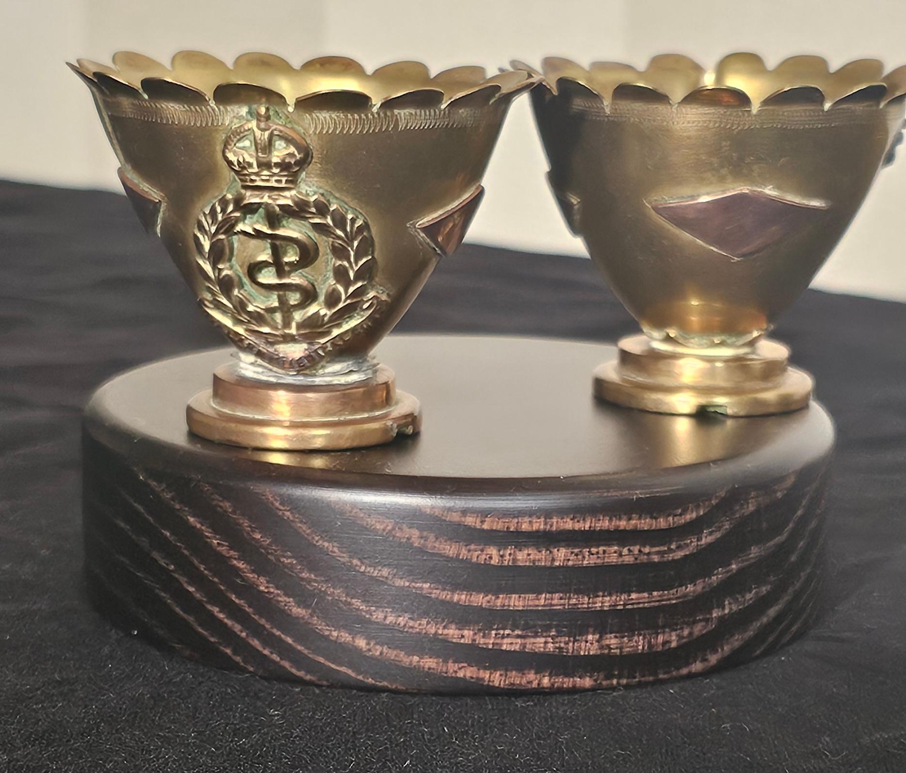 Ces deux coquetiers sont d'excellents exemples de l'art des tranchées de la Première Guerre mondiale. La pièce a été travaillée de manière experte à partir de deux douilles plus petites. Fabriqué à partir de douilles d'obus américains par un membre