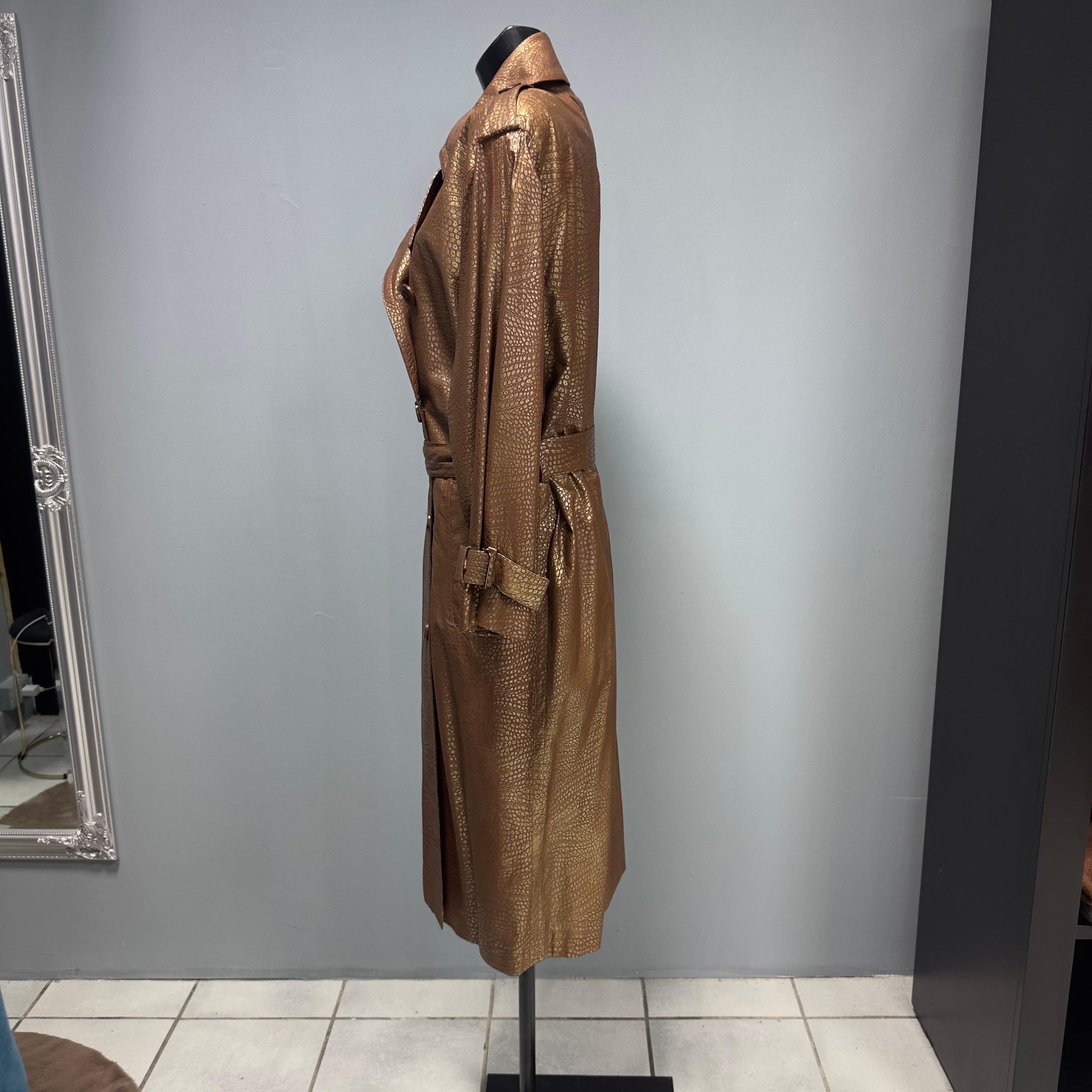 Trench in pelle con cintura Yves Saint Laurent Rive Gauche anni 80 con stampa rettile. Toni del marrone ed oro, abbinabile con tutto.
Cappotto da collezione per sentirsi sempre alla moda con un capo iconico come il Trench.
Tasche laterali, spacco