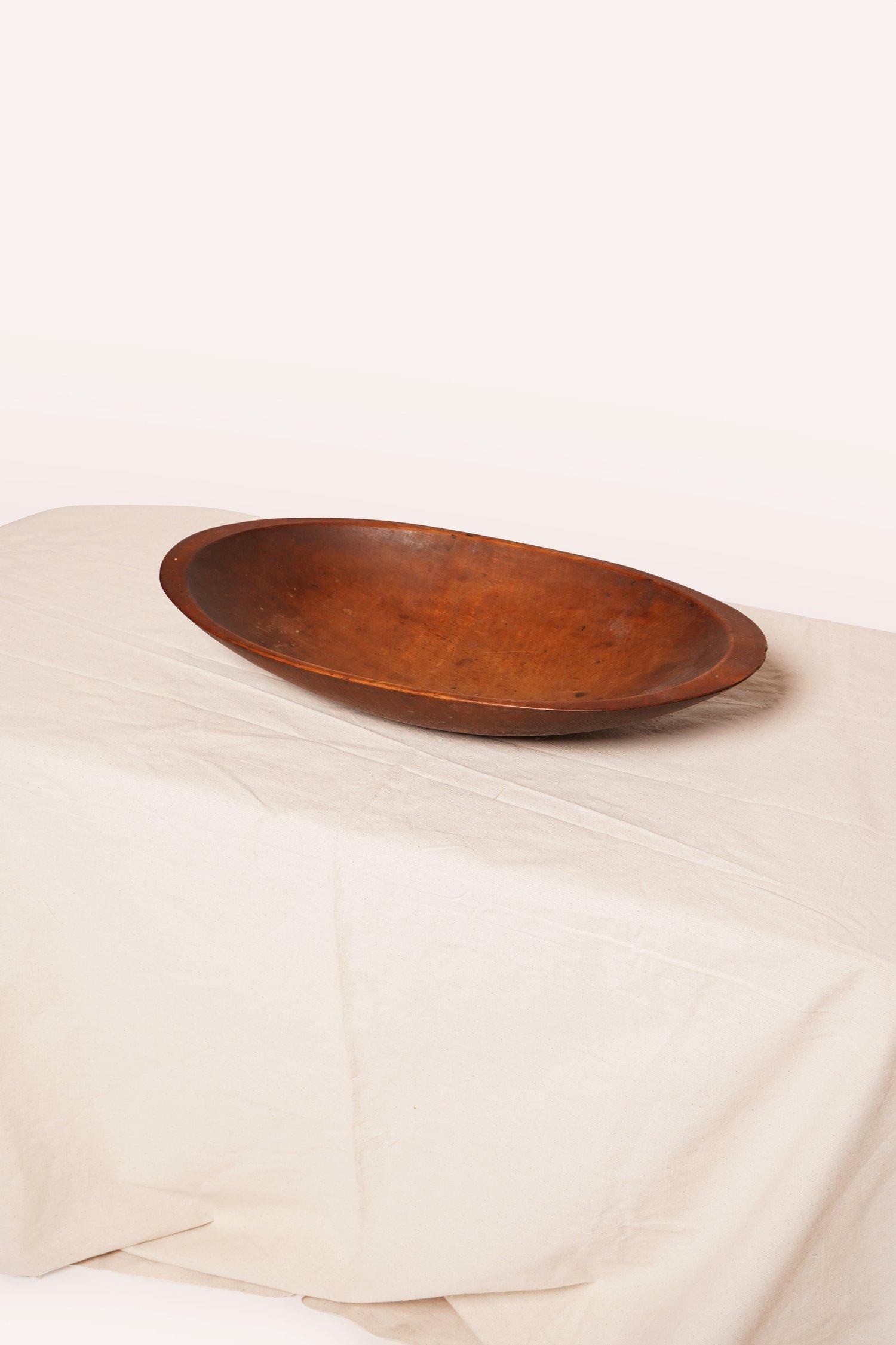 This trencher large oval wooden dough bowl was traditionally used to prepare dough in the 19th century. This bowl can be used for storage or displaying as is.