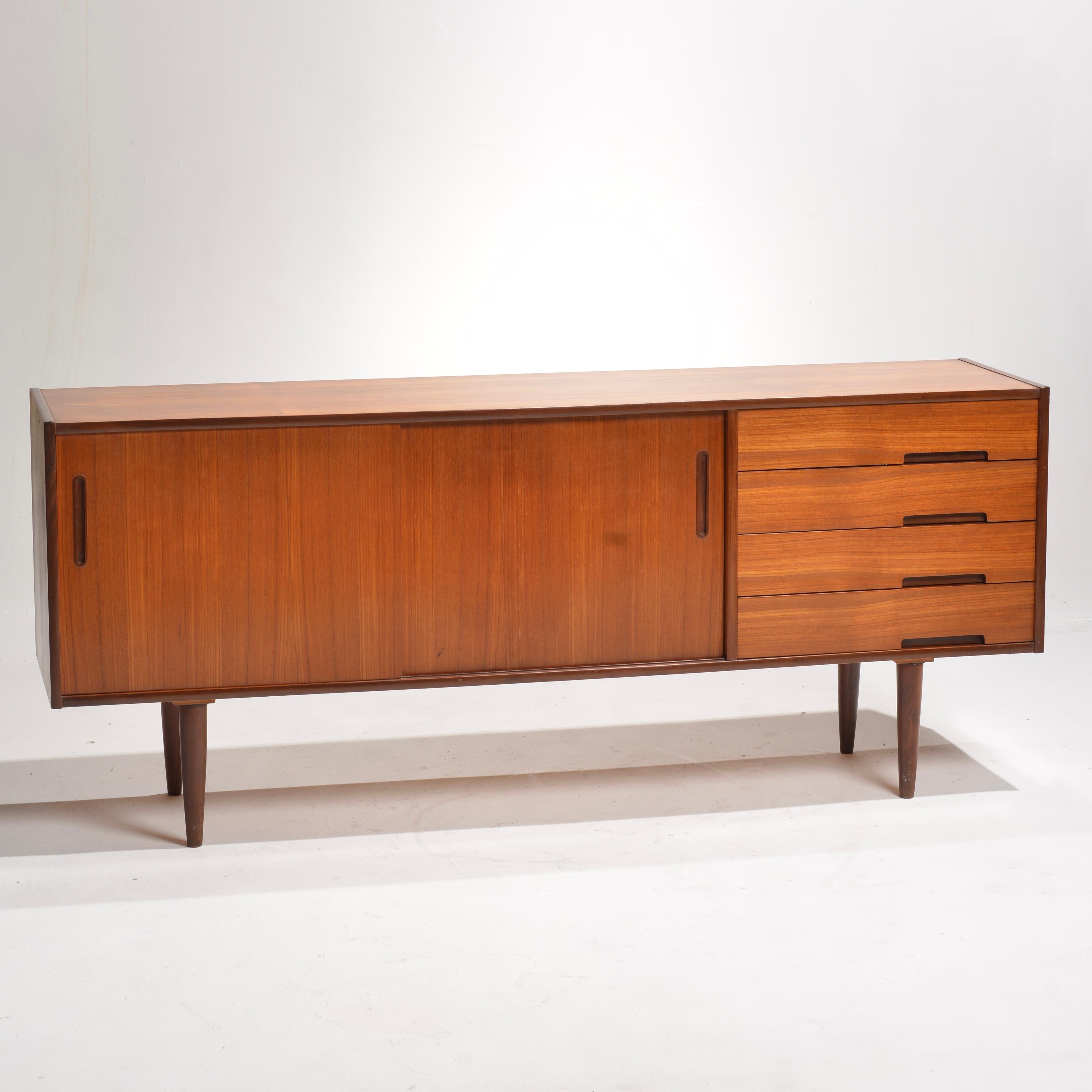 Introducing the stunning teak 'Trento' credenza designed by Nils Jonsson for Hugo Troeds in Sweden. This exceptional piece provides an array of generous storage options such as shelves, and drawers. Highlighting finely contoured drawer pulls,