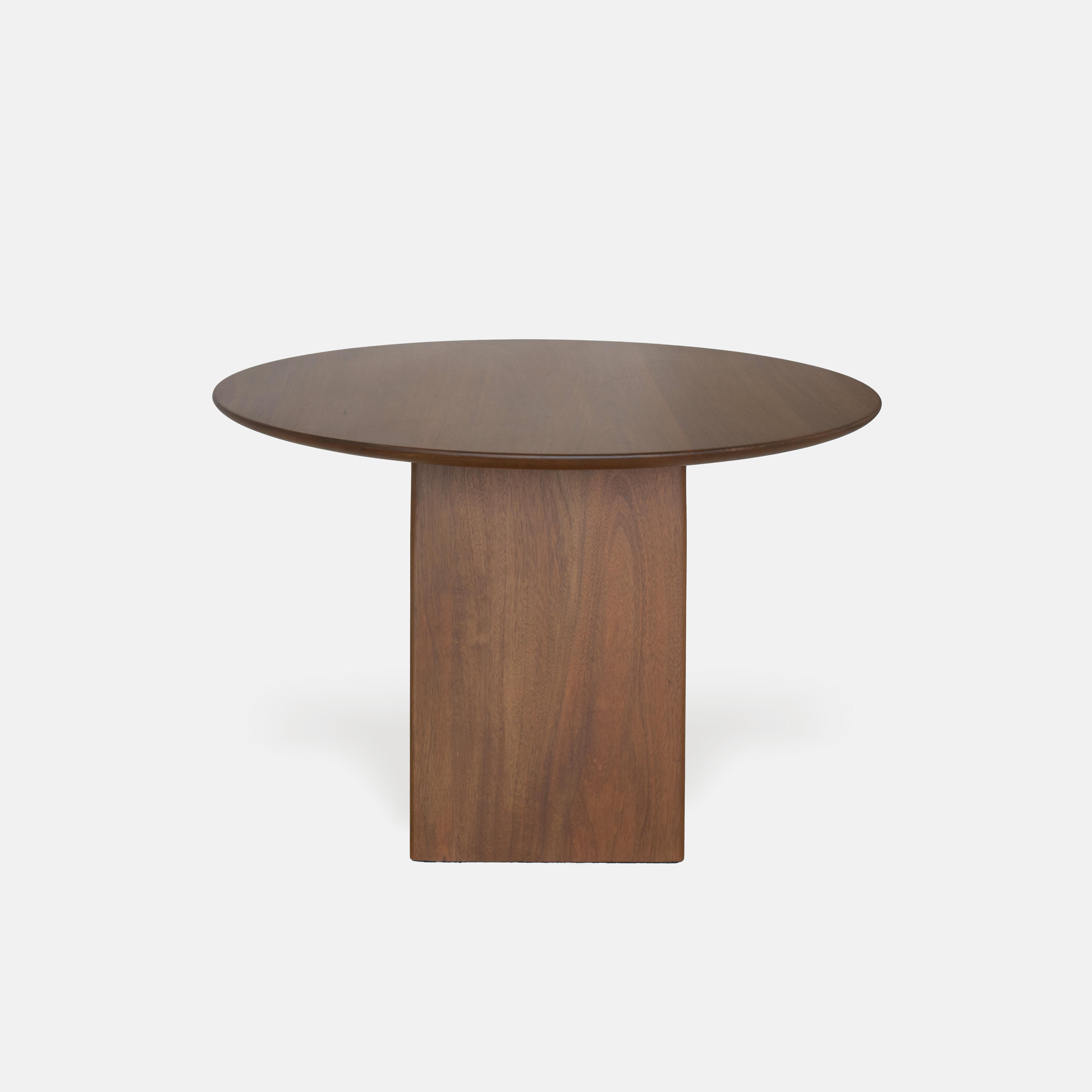 La Três Table se compose de trois parties solides avec une face redressée et un dos arrondi. Le plateau rond conserve une hauteur dans la partie centrale qui permet aux pieds de s'emboîter directement, éliminant ainsi le besoin de verrous dans la