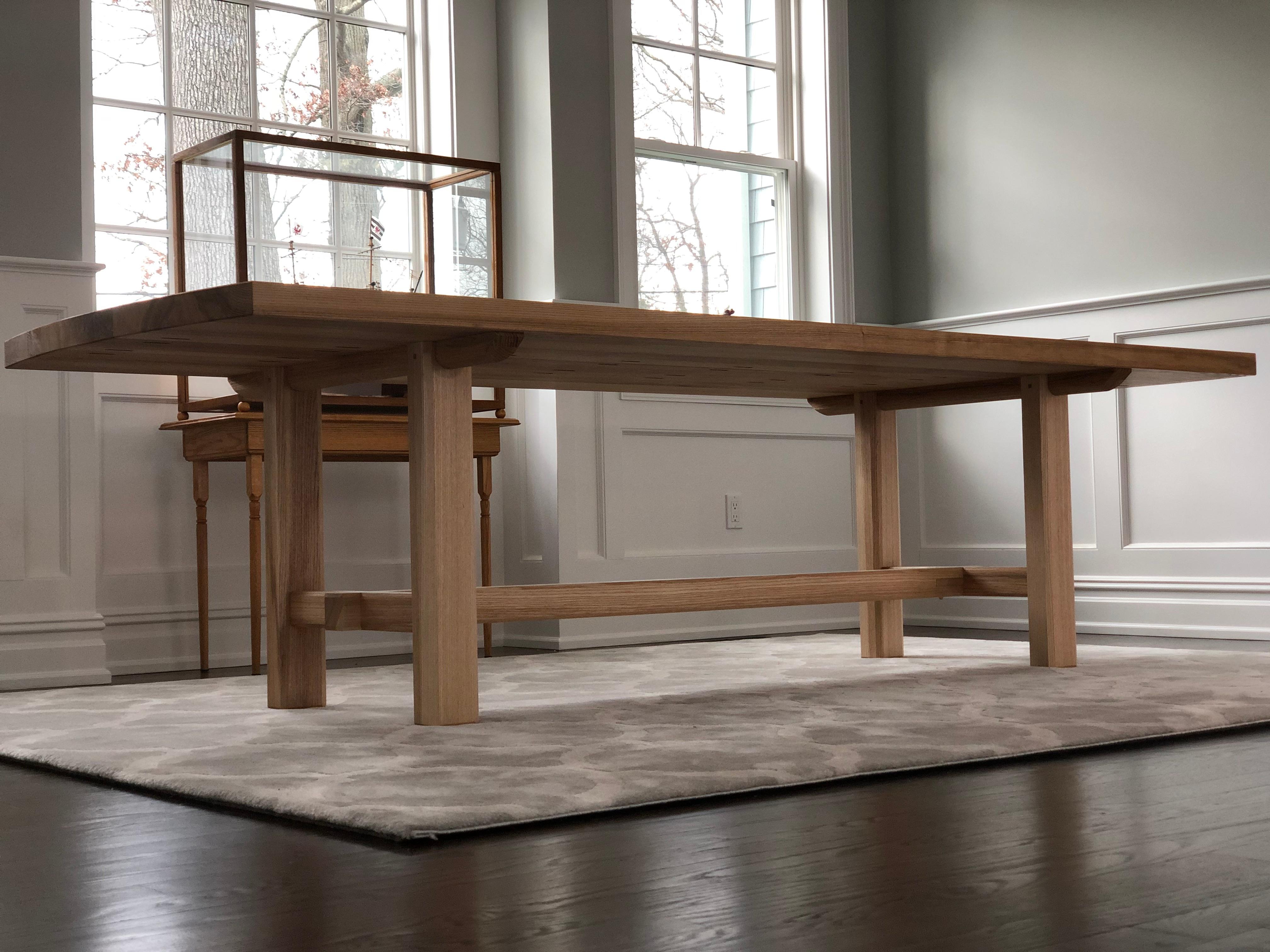 This handmade heavy slab trestle leg dining table features elements unique to traditional Japanese timber framing carpentry work making this a subtle and very sturdy dining table. This table features a heavy slab of quarter sawn white ash, supported