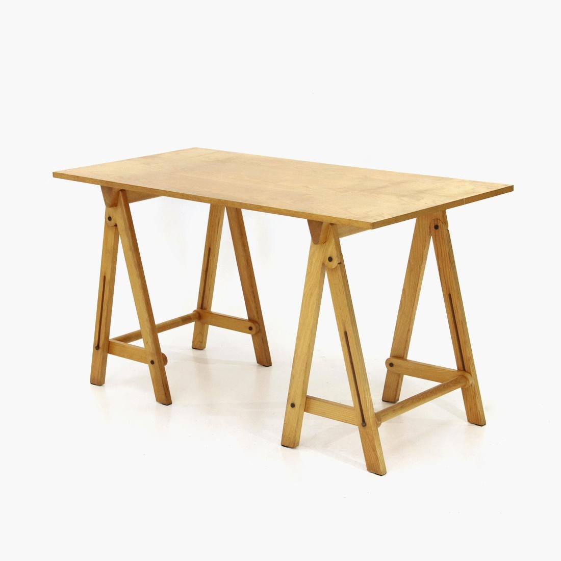 Italian-made table produced in the 1970s.
Rectangular veneered wood top.
Trestle legs in solid wood, foldable when not in use.
Good general condition, some signs due to normal use over time.

Dimensions: Length 140 cm, depth 65 cm, height 75 cm.