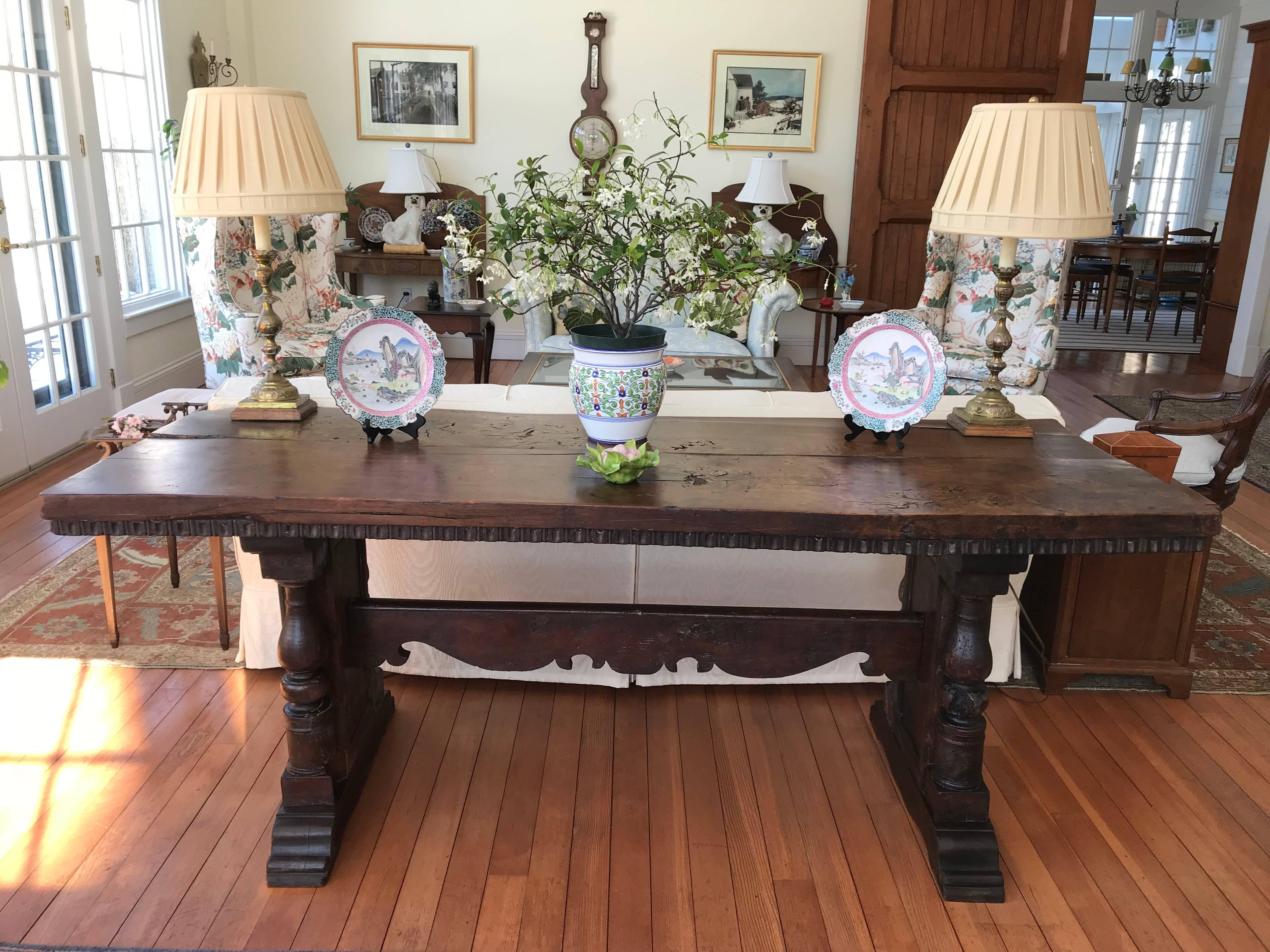 This late 19th century this Italian trestle table is constructed of solid Walnut, the two plank top is hand cut and honed of burr walnut and has a stunning deep honey color.
