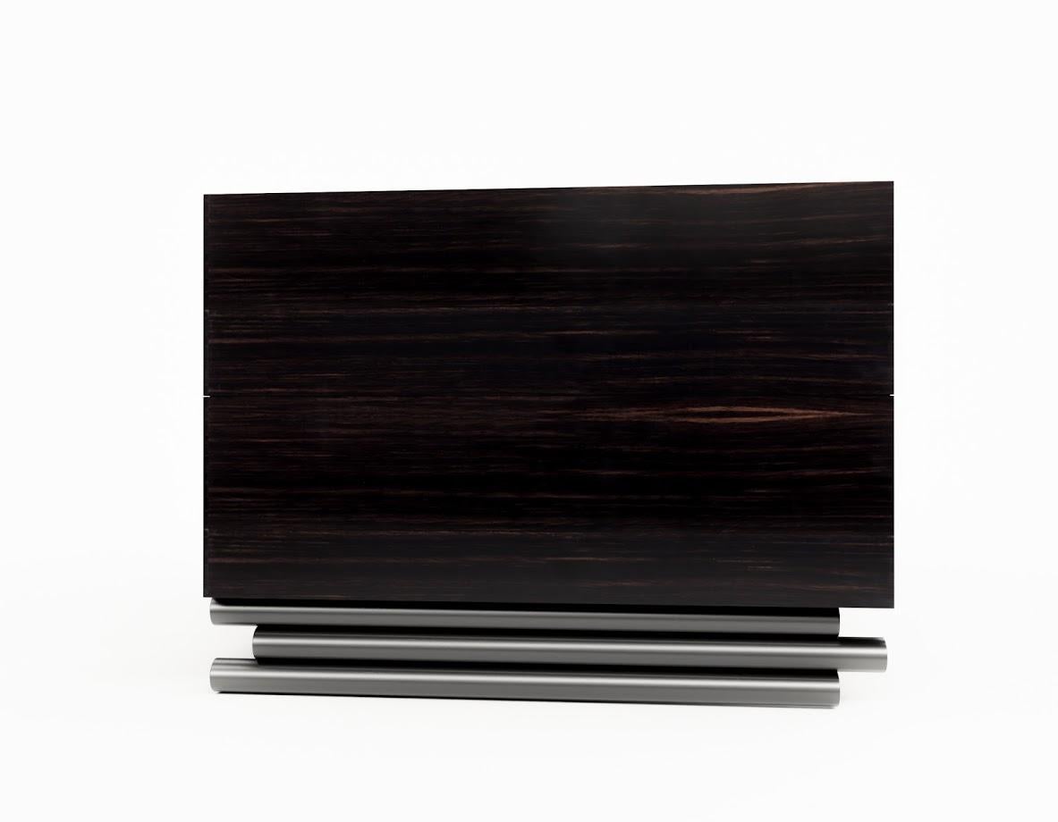 TRESTLES NIGHTSTAND - Modern Ebony Walnut with Silver Metallic Base

The Trestles Nightstand is a beautiful piece of furniture that combines modern urban influences with fine craftsmanship. It features two drawers with soft close glides, providing