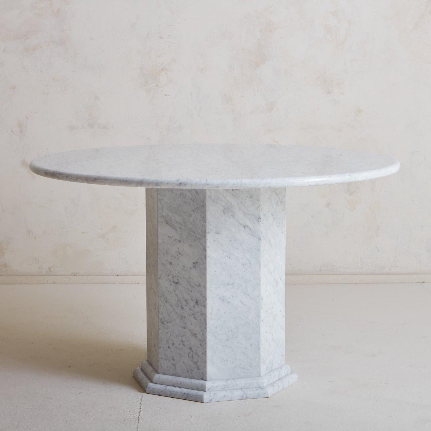 Une superbe table de salle à manger en marbre de Carrare conçue sur mesure par South Loop Loft. Cette table est dotée d'un plateau rond d'un pouce d'épaisseur reposant sur une base octogonale à bord biseauté avec un détail de bord à double