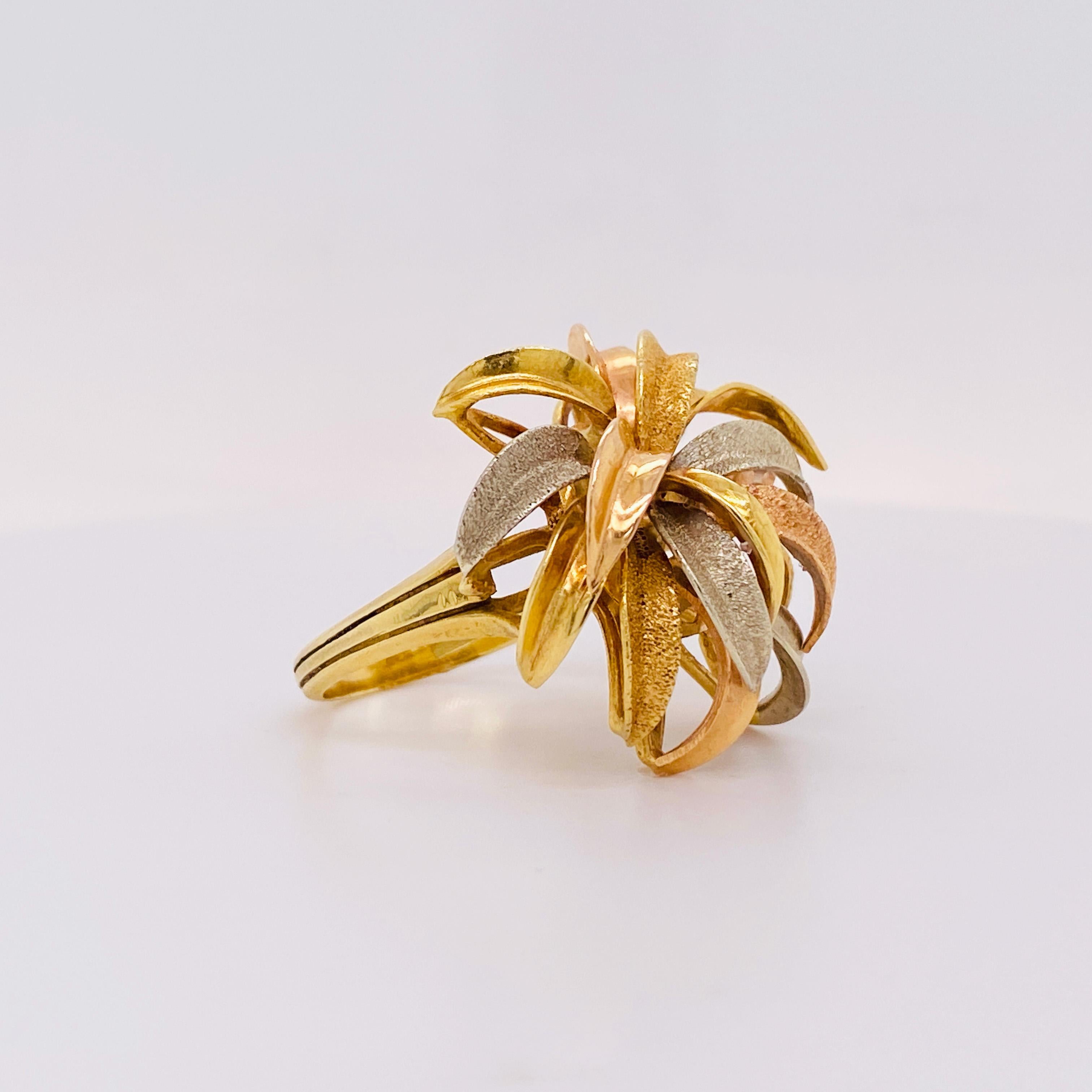This ring design sparks of a multicolor fireworks display, or the gracefully arching crown of leaves of a Dracaena corn plant. This gorgeous tri-color 18 karat gold ring that looks perfect with any skin tone! This ring has a unique design that will